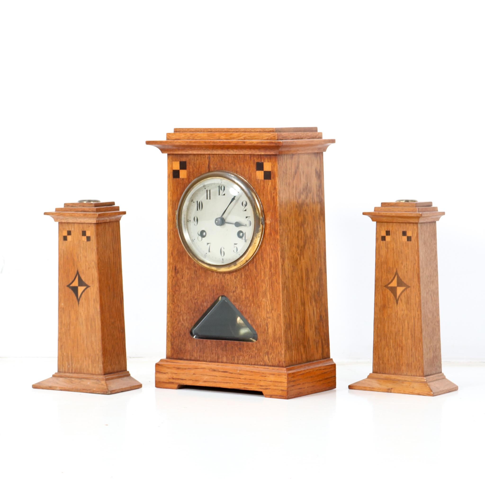 Stunning Art Nouveau Jugendstil clock set with mantel clock and two candle sticks.
Striking Dutch design from the 1900s.
Solid oak with inlay and original key.
This wonderful clock set is in very good original condition with minor wear consistent
