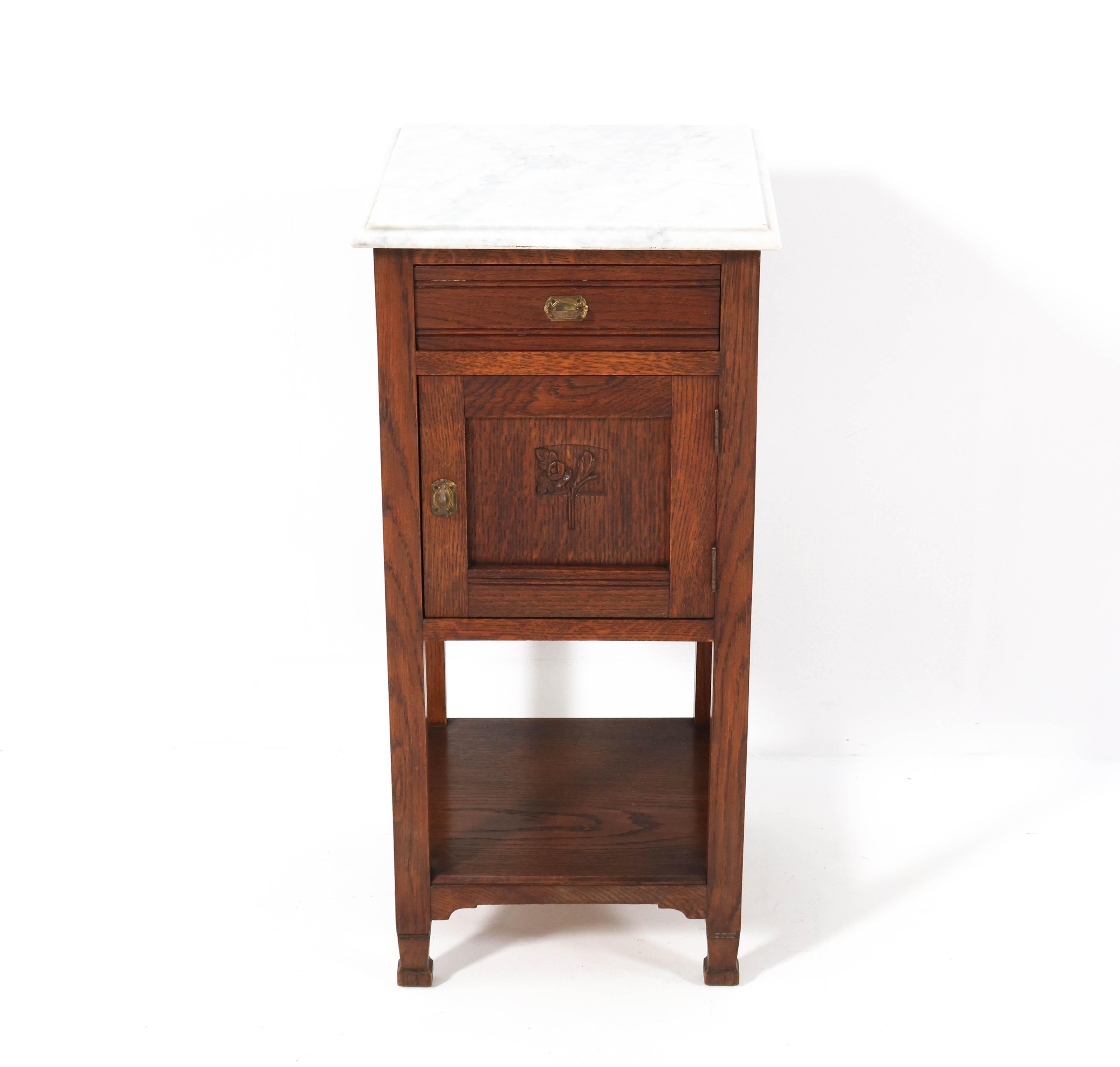 Stunning Art Nouveau nightstand.
Striking Dutch design from the 1900s.
Solid oak with original brass handles.
Original marble top.
In very good condition with a beautiful patina.