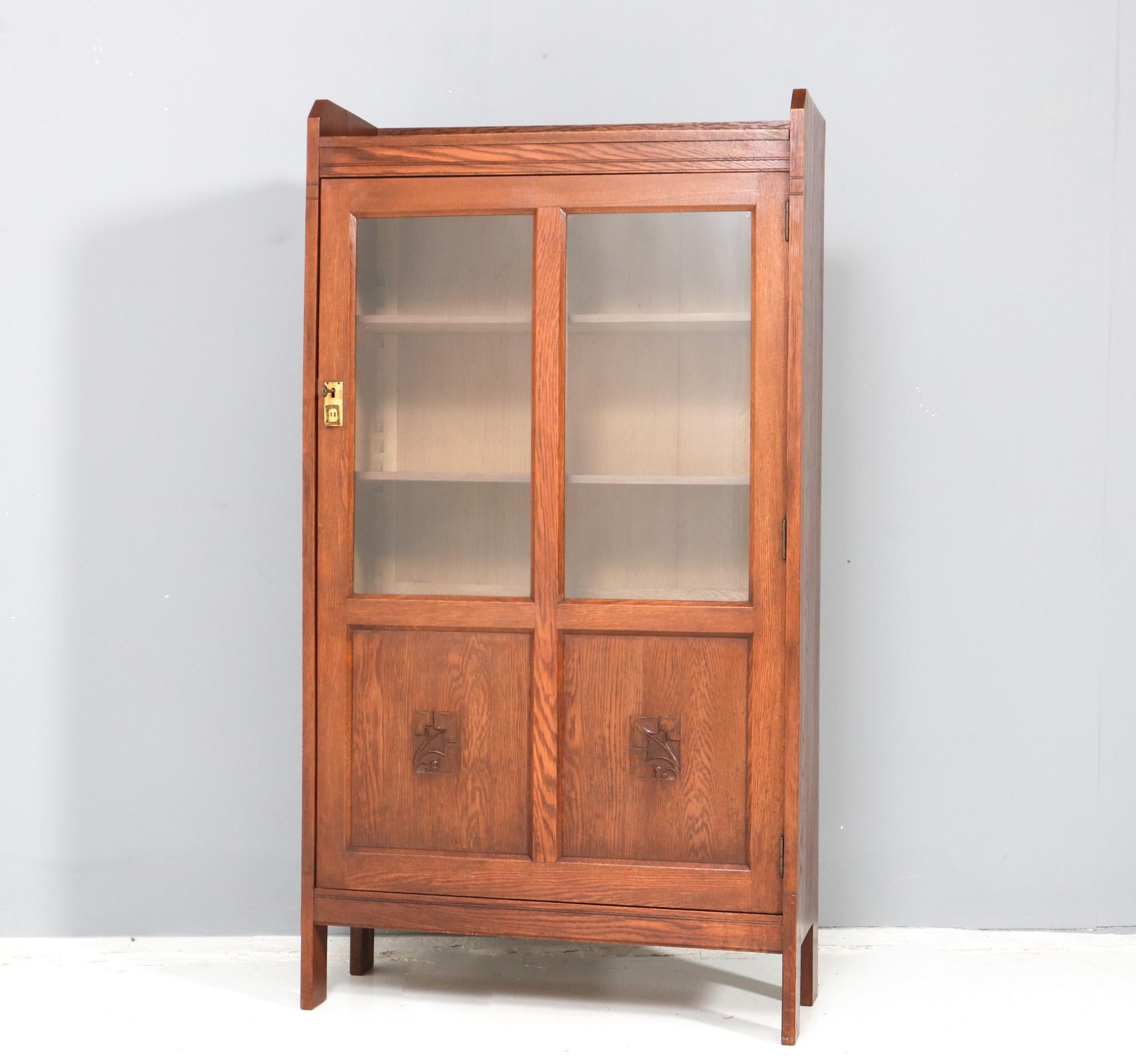 Stunning and rare Art Nouveau one-door bookcase.
Striking Dutch design from the 1900s.
Solid oak with original beveled glass in the door.
Three solid oak shelves, adjustable in height.
Original brass handle with original lock and key in good working