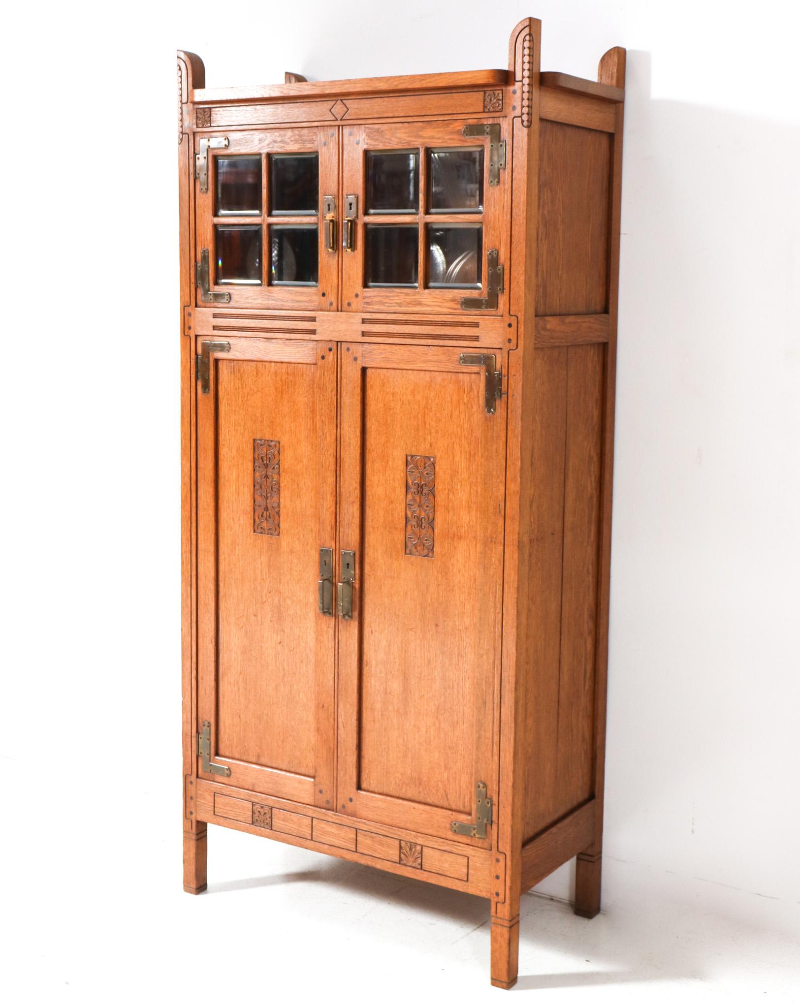 Magnificent and ultra rare Arts & Crafts armoire.
Design by Willem Penaat for Fa. Haag & Zn Amsterdam.
Striking Dutch design from 1897.
Solid oak frame with original patinated brass handles on the four doors.
The eight patinated brass hinges are
