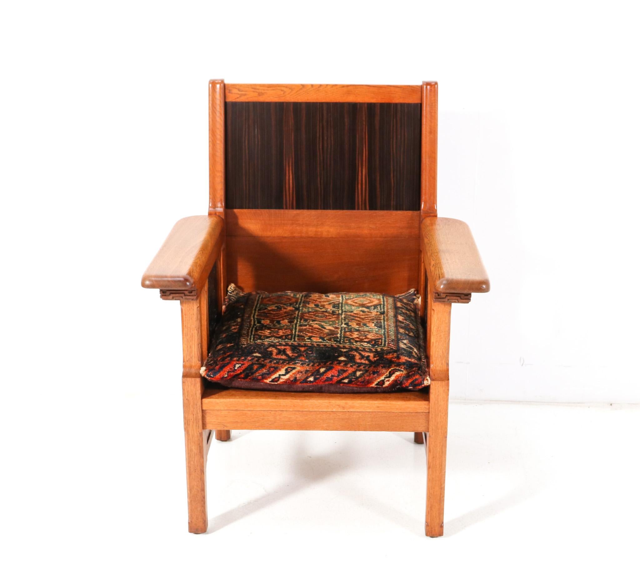 Magnificent and rare Arts & Crafts Art Nouveau armchair.
Design attributed to Carel Adolph Lion Cachet.
Solid oak base with original hand-carved elements.
Original solid macassar ebony hand-carved elements underneath the armrests.
The backside