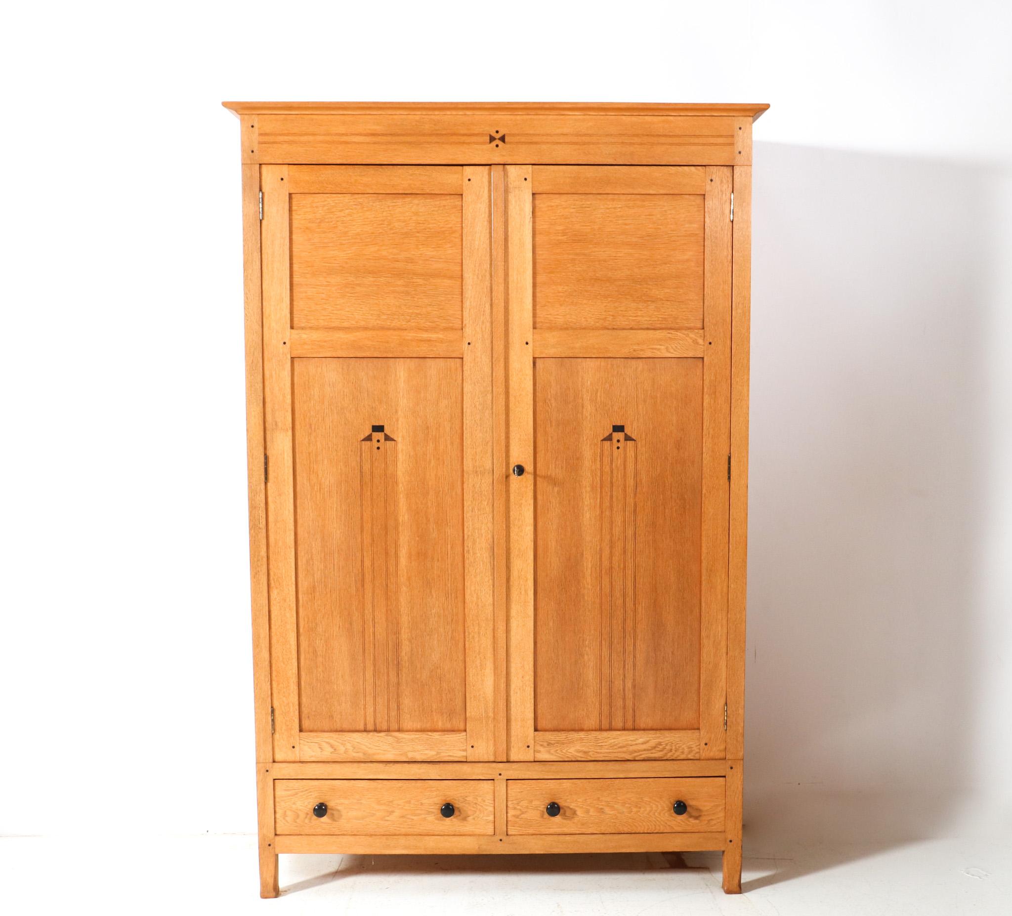 Magnificent and ultra rare Arts & Crafts Art Nouveau armoire or wardrobe.
Design by Jac. van den Bosch.
Striking Dutch design from the 1900s.
Solid oak base with original solid ebony knobs and original ebony decorative elements.
Four original wooden