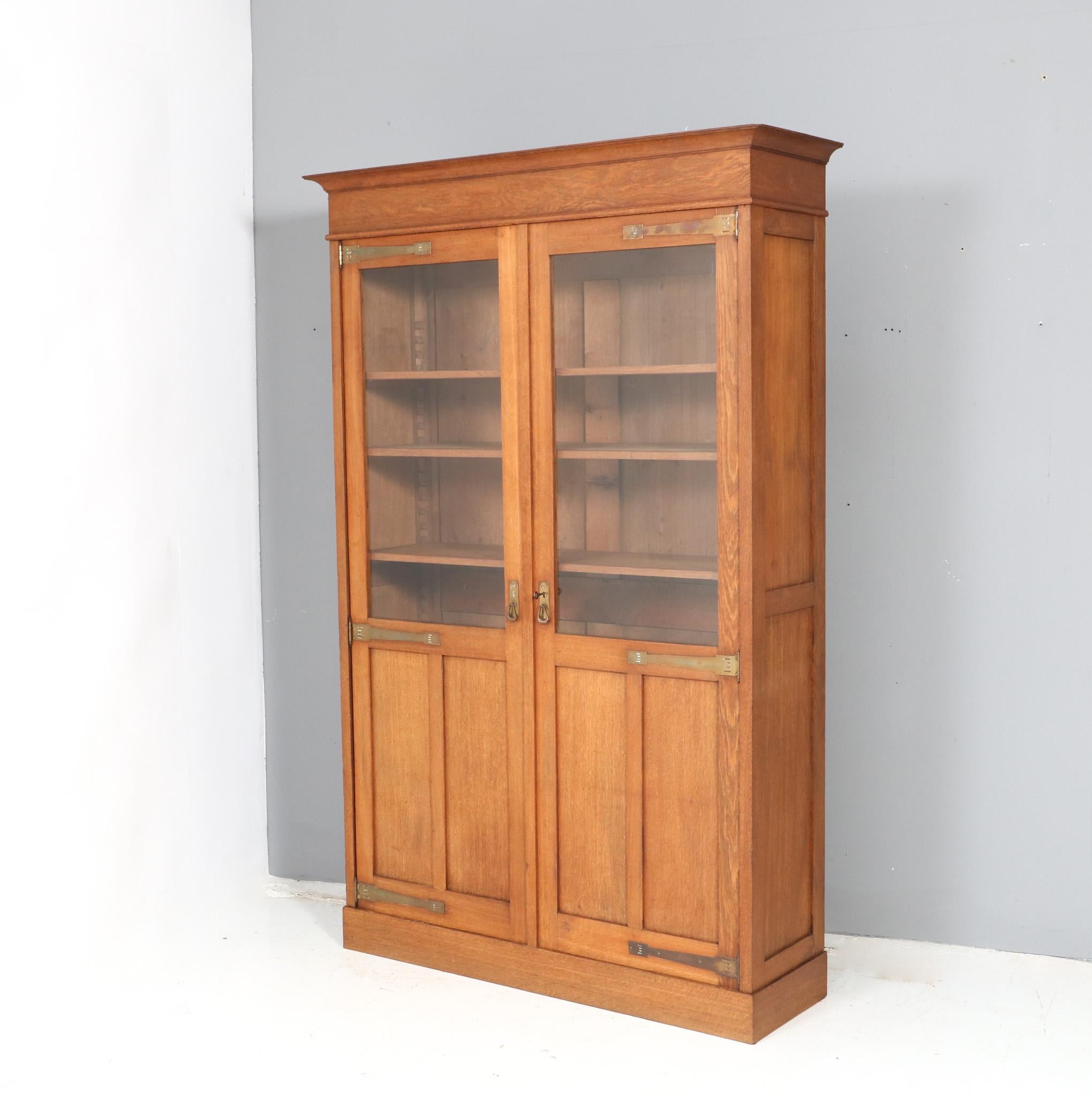 Magnificent and rare Arts & Crafts Art Nouveau bookcase.
Striking Dutch design from the 1900s.
Solid oak base with original patinated brass handles and hinges.
Six original wooden shelves, adjustable in height.
This wonderful Arts & Crafts Art