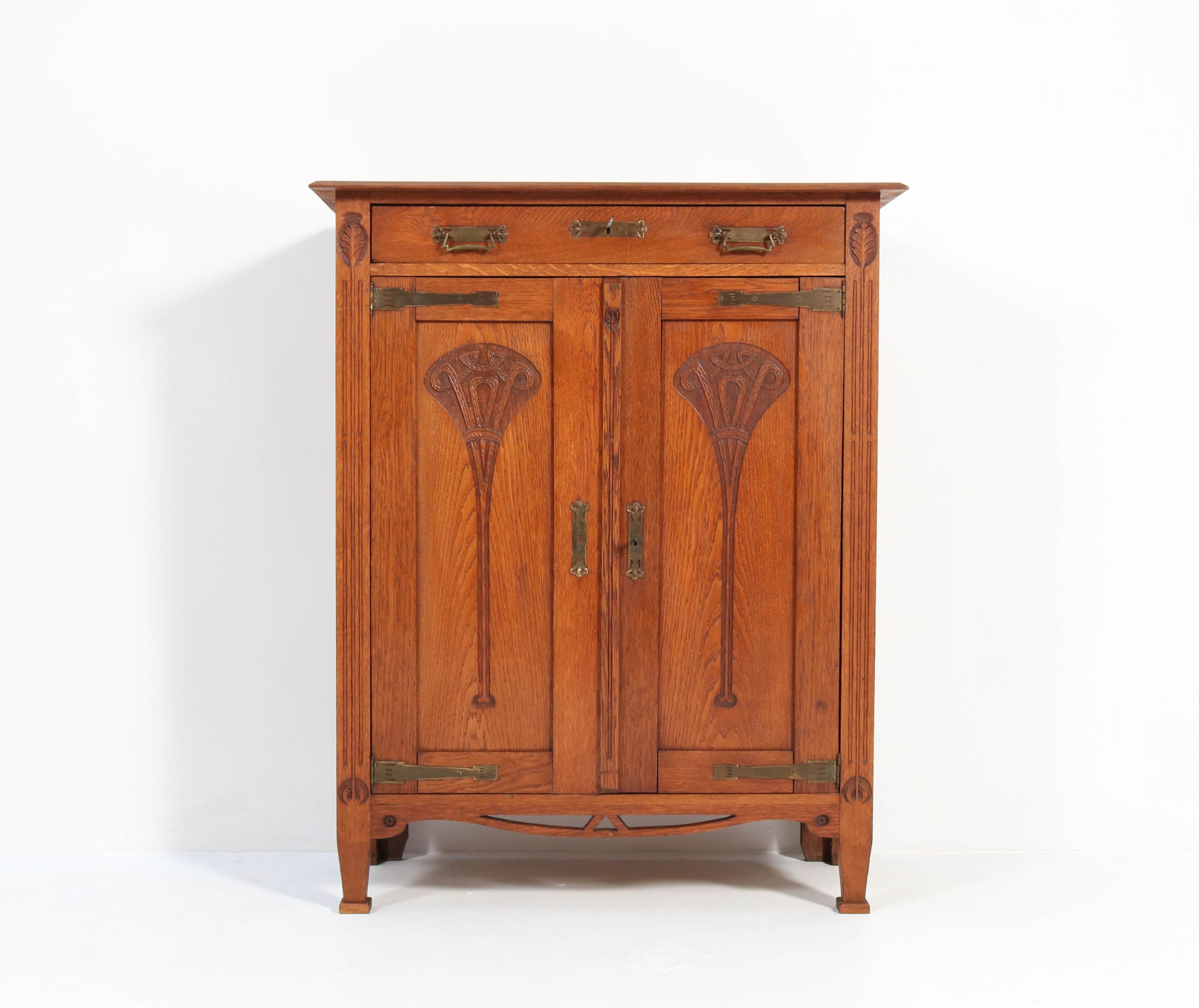 Wonderful and rare Arts & Crafts Art Nouveau cupboard.
Striking Dutch design from the 1900s.
Solid oak with original solid brass hinges.
Three original oak shelves adjustable in height.
In very good condition with minor wear consistent with age