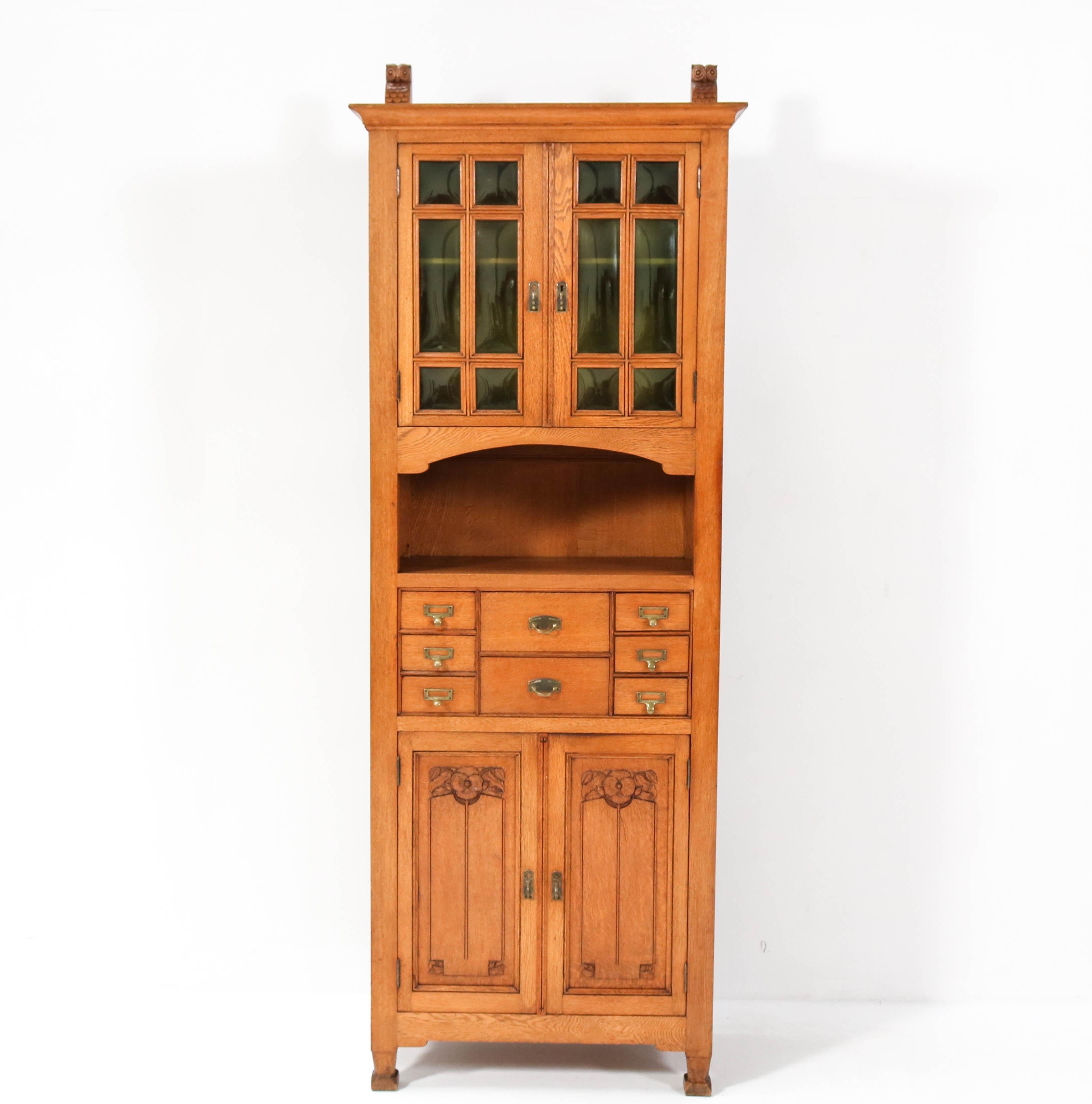 Magnificent and ultra rare Arts & Crafts Art Nouveau cabinet
Design attributed to Kobus de Graaff.
Striking Dutch design from the 1900s.
Solid oak with stylish hand-carved owls on top of the cabinet
Original green glass and original brass