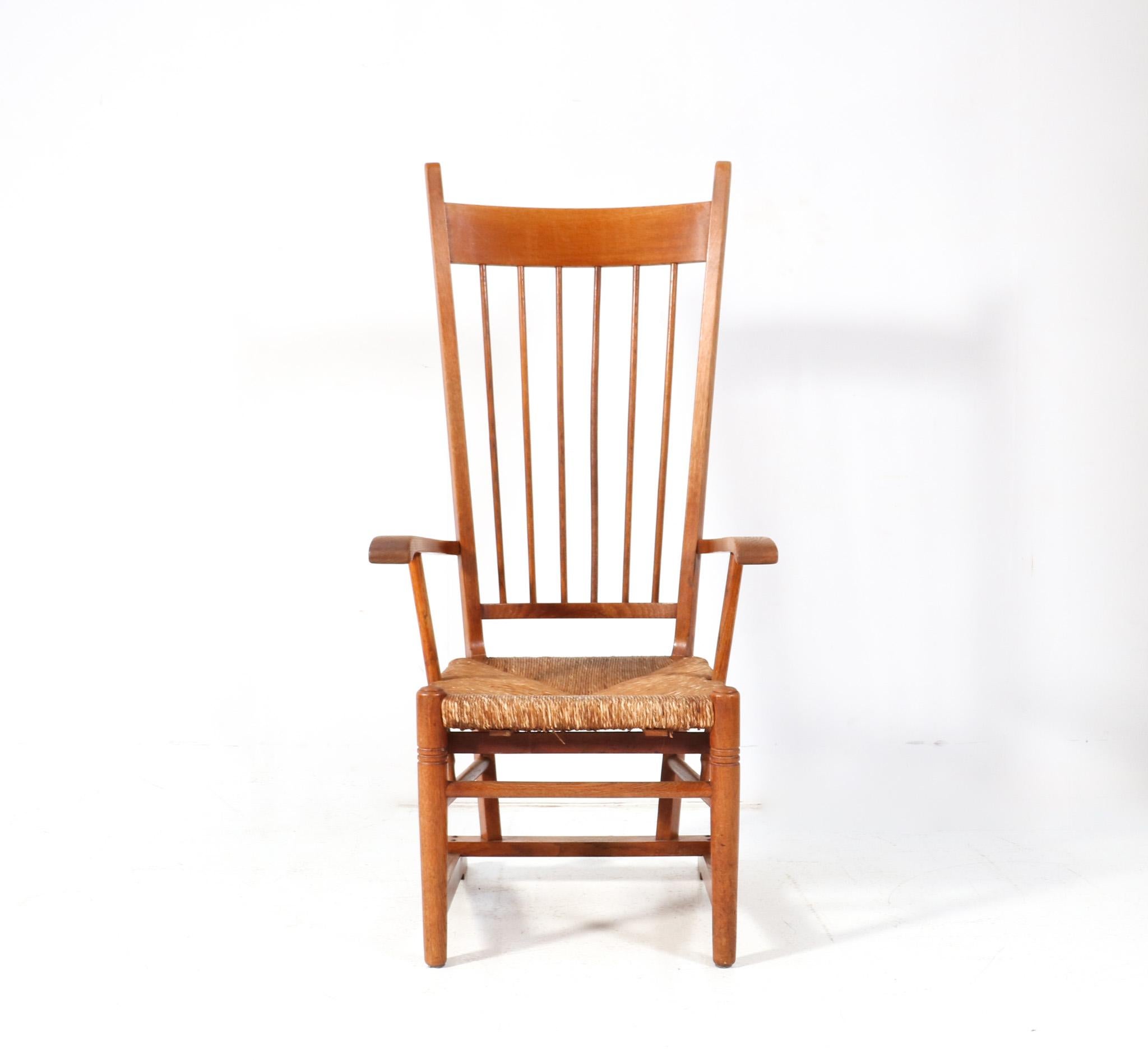 Stunning and rare Arts & Crafts Art Nouveau high back armchair.
Striking Dutch design from the 1900s.
Solid oak frame with original rush seat.
Well designed tall back and elegant and sleek rear legs.
This wonderful Arts & Crafts Art Nouveau high