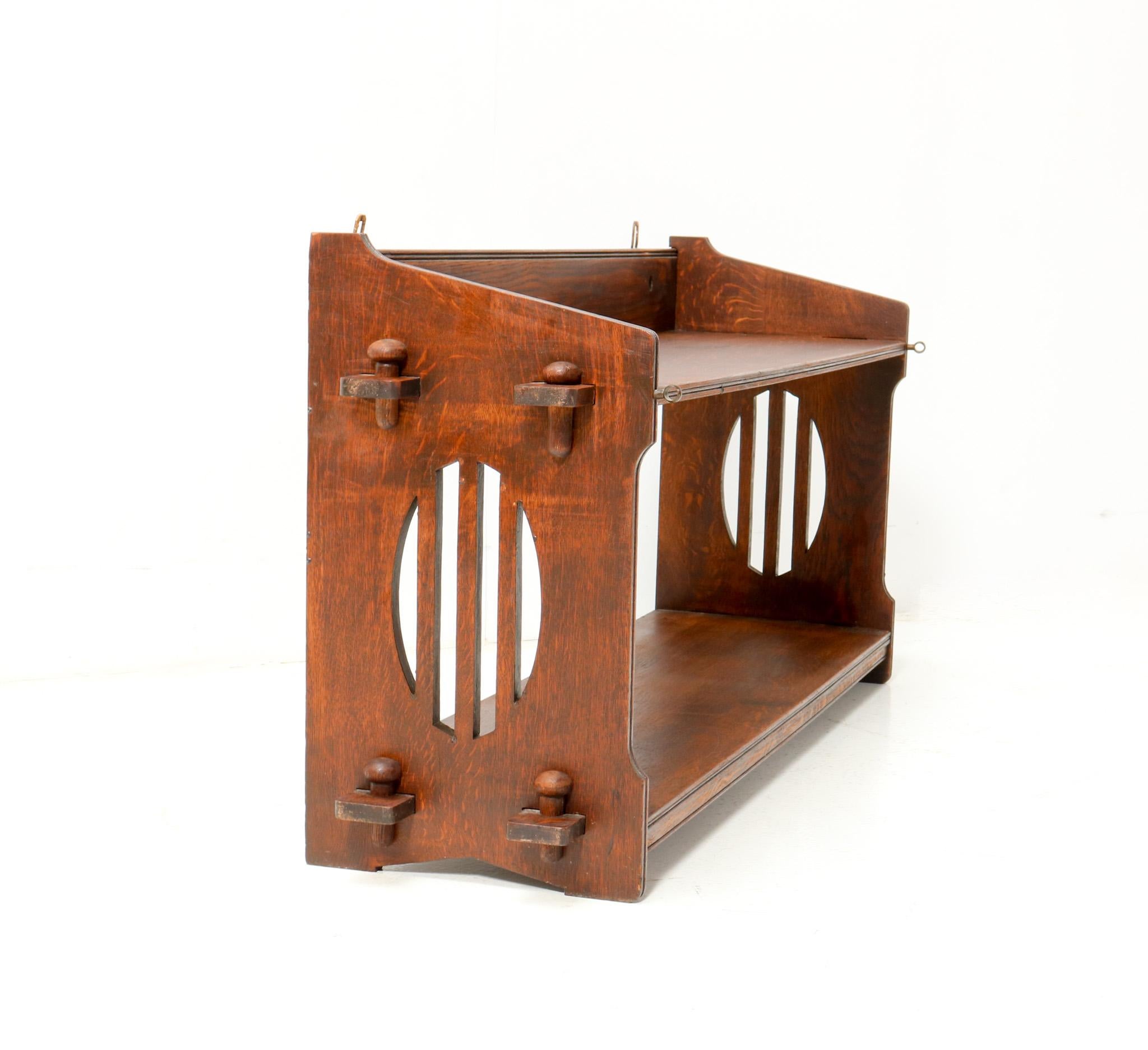 Stunning and rare Arts & Crafts Art Nouveau magazine rack or book rack.
Design by Aug. Zeiss & Cie. Paris.
Striking French design from the 1900s.
Solid oak with original decorative elements.
Marked with original manufacturers metal tag.
This