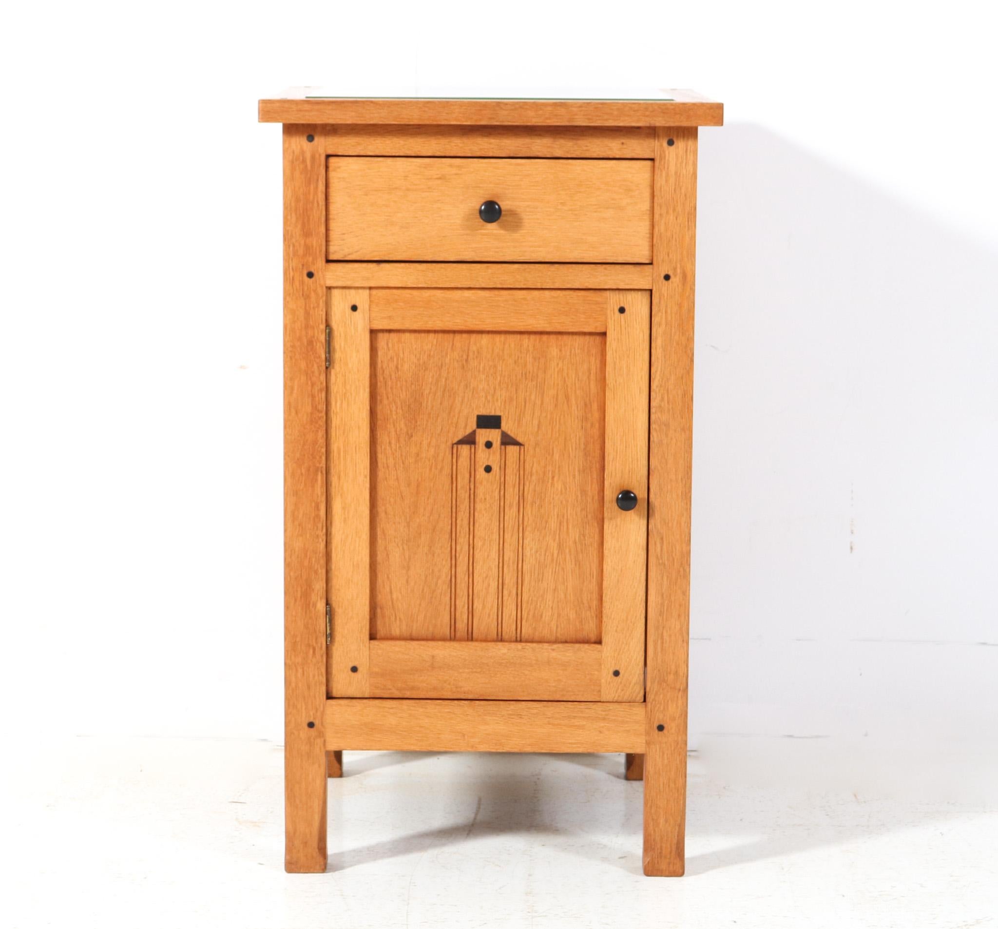 Magnificent and ultra rare Arts & Crafts Art Nouveau nightstand or bedside table.
Design by Jac. van den Bosch.
Striking Dutch design from the 1900s.
Solid oak base with original solid ebony knobs on door and drawer.
This wonderful Arts & Crafts Art