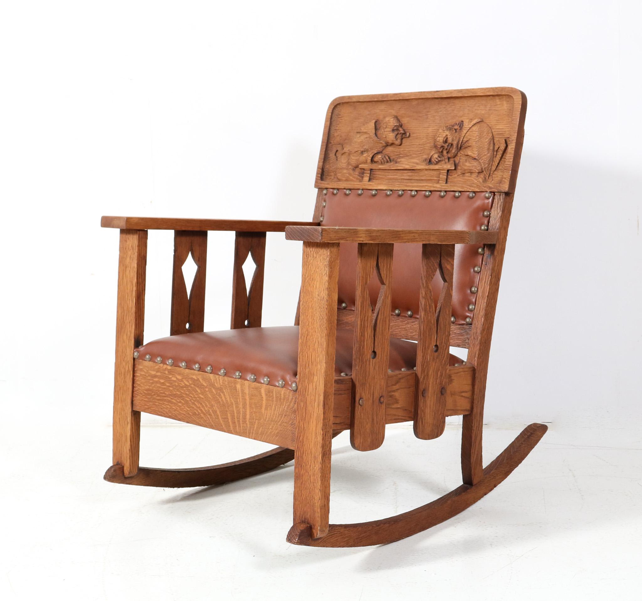 Magnificent and rare Arts & Crafts Mission rocking chair.
Striking American design from the 1900s.
Quarter-sawn oak frame with two hand-carved monks in the back rest.
The rocking chair has been re-upholstered with a high quality and thick brown