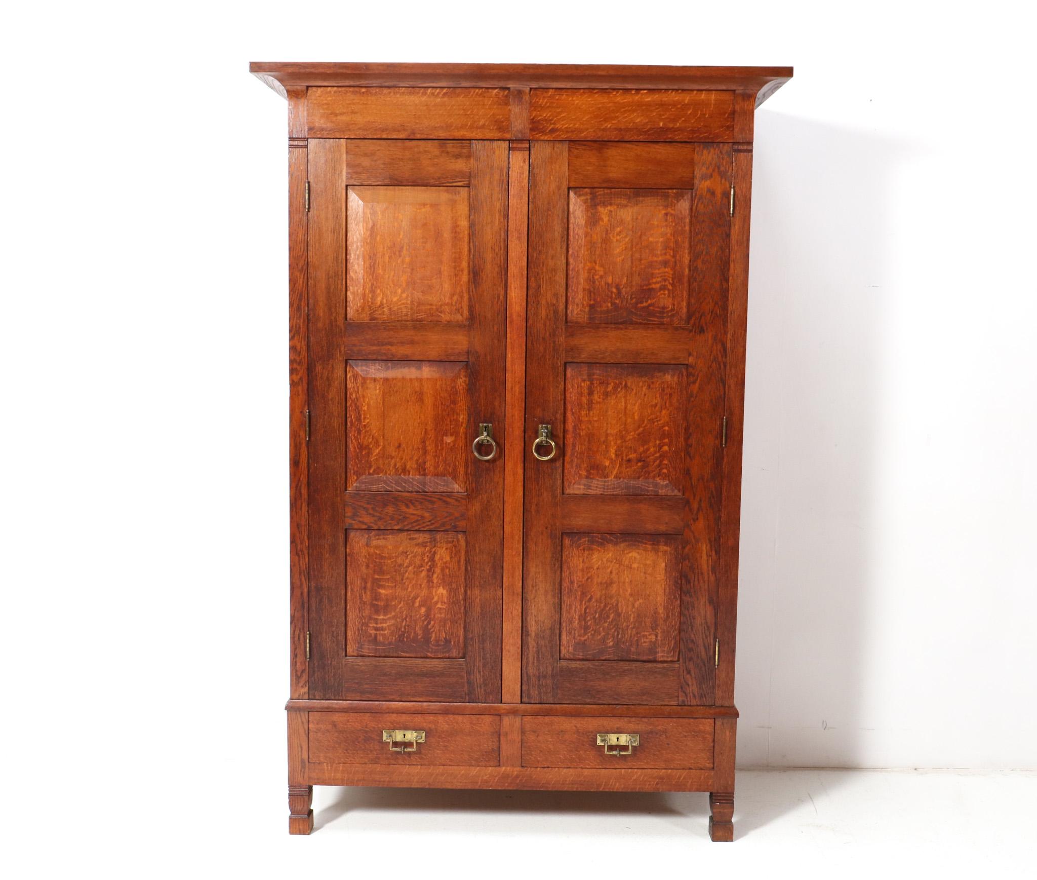 Magnificent and ultra rare Arts & Crafts Rationalist armoire or wardrobe.
Design by Willem Penaat for De Woning Amsterdam.
Striking Dutch design from the 1900s.
Solid oak with original brass handles on doors and drawers.
The brass handles were