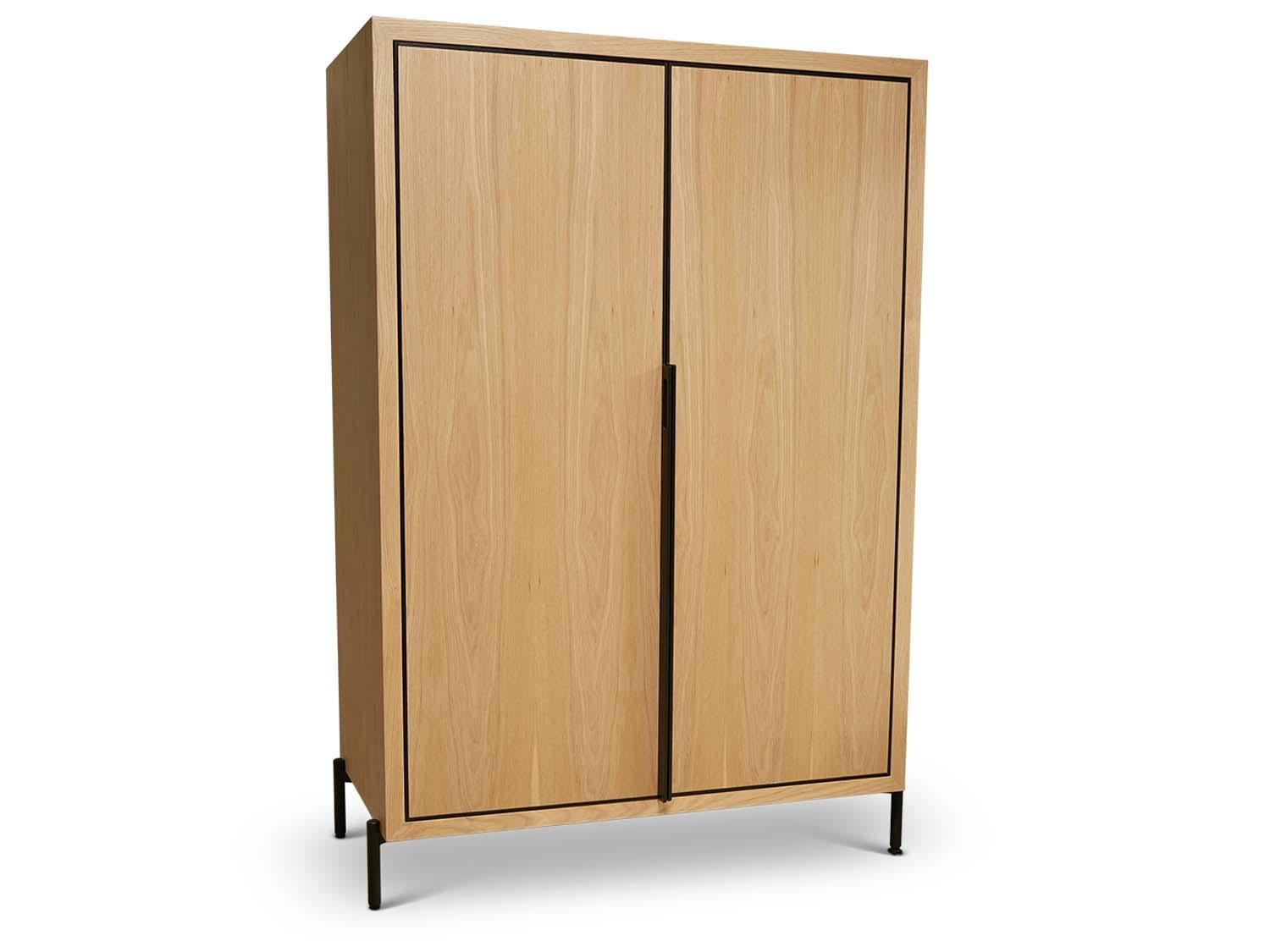 The Balboa Tall Cabinet features two doors wrapped in a brass band which extrude out to become an elegant hand tooled brass pull. The case is available in American walnut or white oak and rests above a tubular steel base. The interior has six