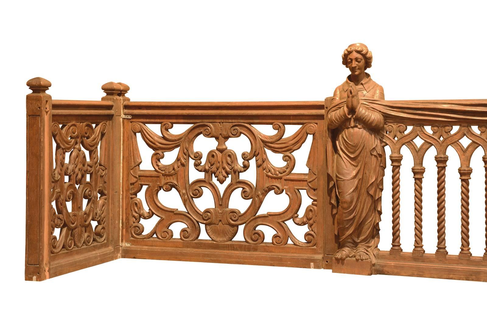 Dated from the 19th century, oak balustrade neogothic style. With two saints praying on either side of nine columns, the balustrade is also composed of four panels decorated with windings, draperies and acanthus leaves. Three elements of stair