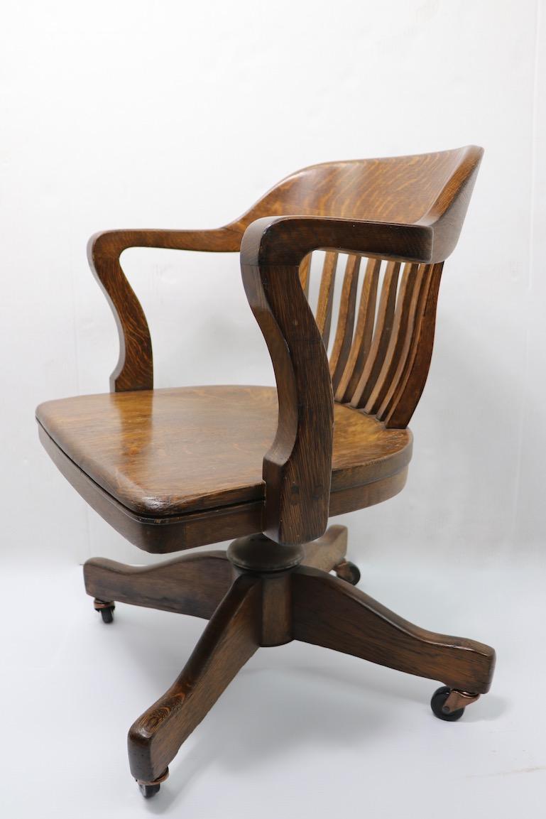 Nice bank of England swivel oak office chair. This example is in very clean condition, recently, but not newly refinished, ready for immediate use. Swivel, and tilt mechanisms function smoothly, some adjustment in seat height possible, unexpectedly