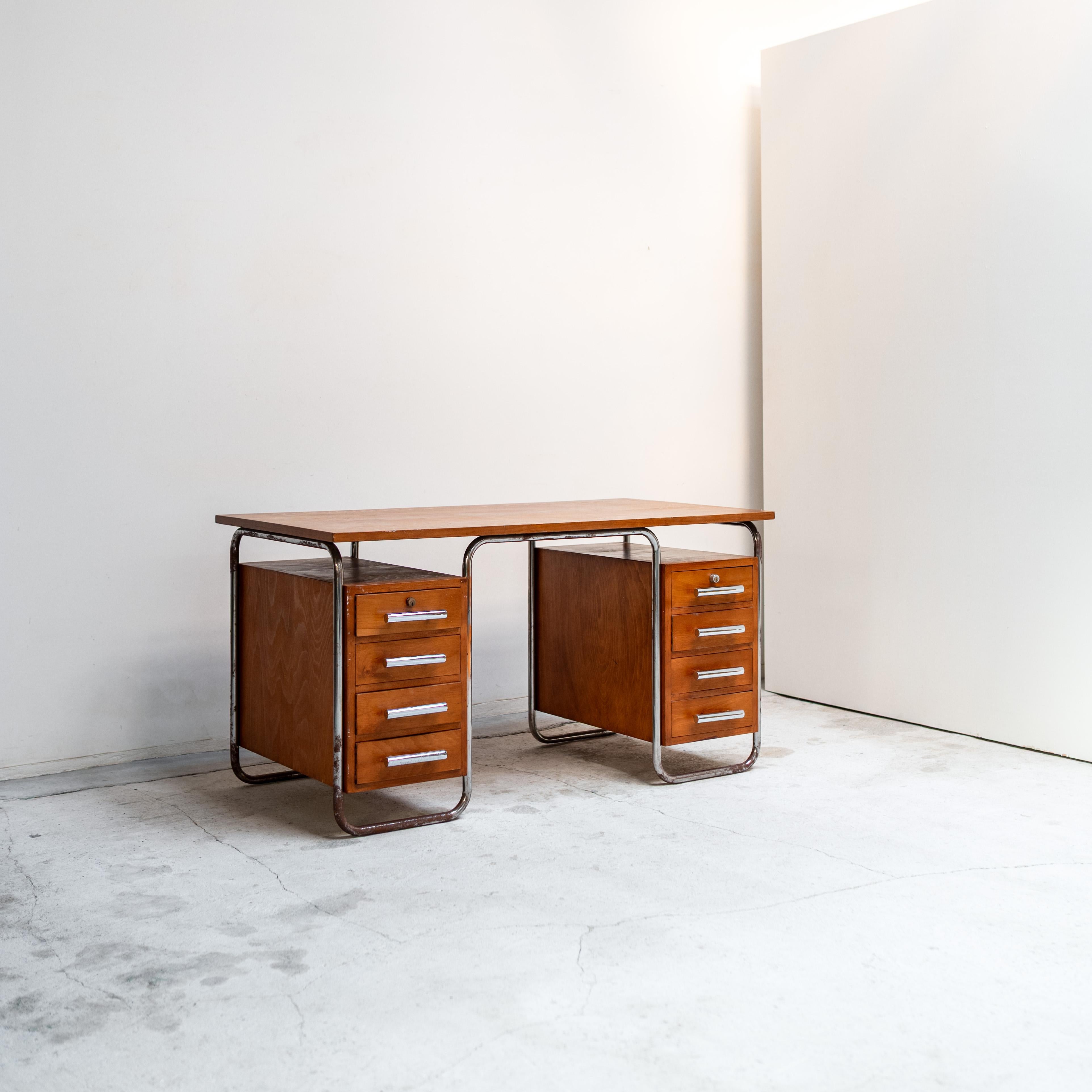A rare and iconic Bauhaus-era writing desk by Marcel Breuer. This beautifully balanced piece exemplifies Breuer’s mastery of modernist design with its striking blend of warm wood cabinetry and chromed tubular steel framing. The desk features twin