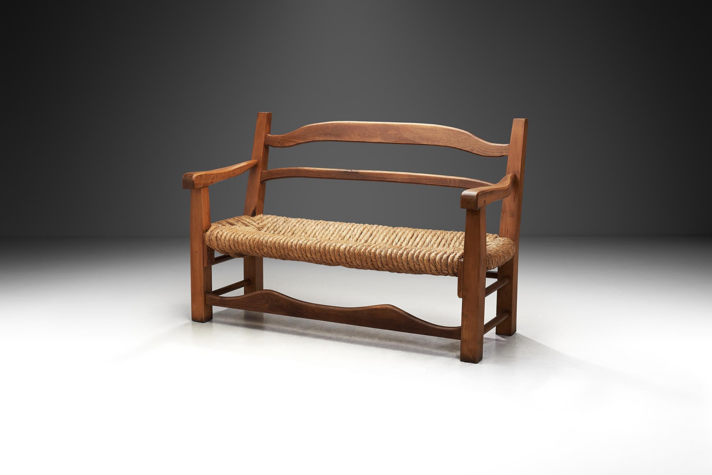 This mid-century bench shows the French cabinetmaking tradition of taking advantage of natural materials and masterfully executed constructions. The subtle curvature of the construction gives this piece an artistic flair while the overall impression