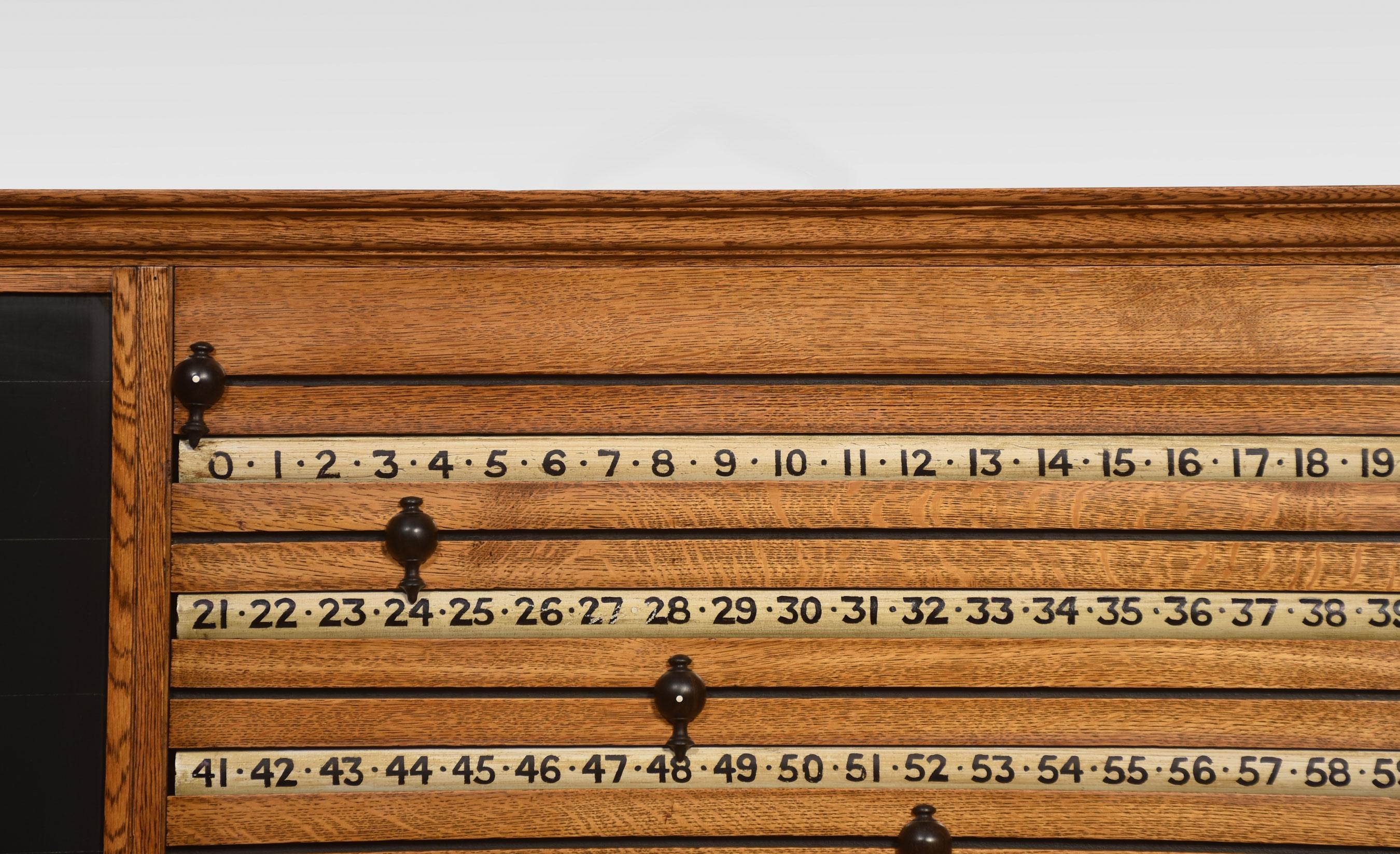 Billiards scoreboard encased in an oak frame having four roller scores with ebonised markers and knobs. Retaining the original chalkboard.
Dimensions
Height 20 Inches
Width 43.5 Inches
Depth 3.5 Inches.
