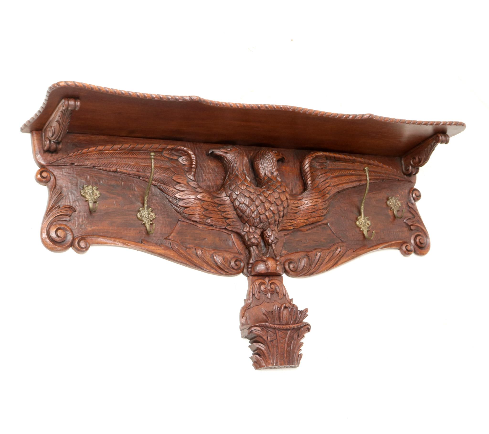 Magnificent and ultra rare Black Forest style wall coat rack.
Striking European design from the 1900s.
Solid oak frame with a hand-carved sculptured double-headed eagle.
Four patinated brass decorative hooks.
This wonderful Black Forest style