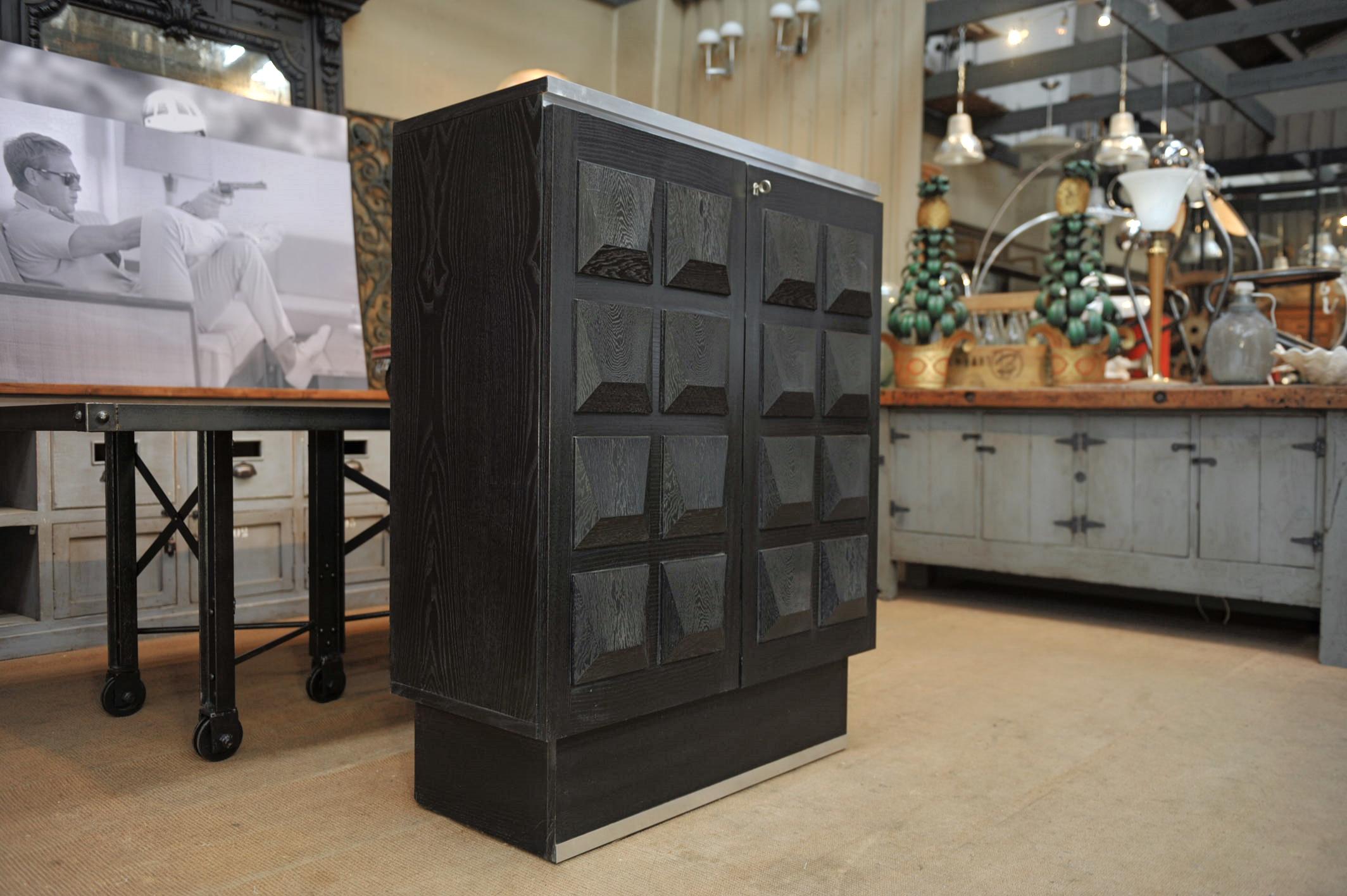 Brutalist ebonized oak buffet cabinet with two doors showing great front sculptural Graphic panels. Aluminum frame and original working key. Three Removable inside shelves, circa 1970.



 