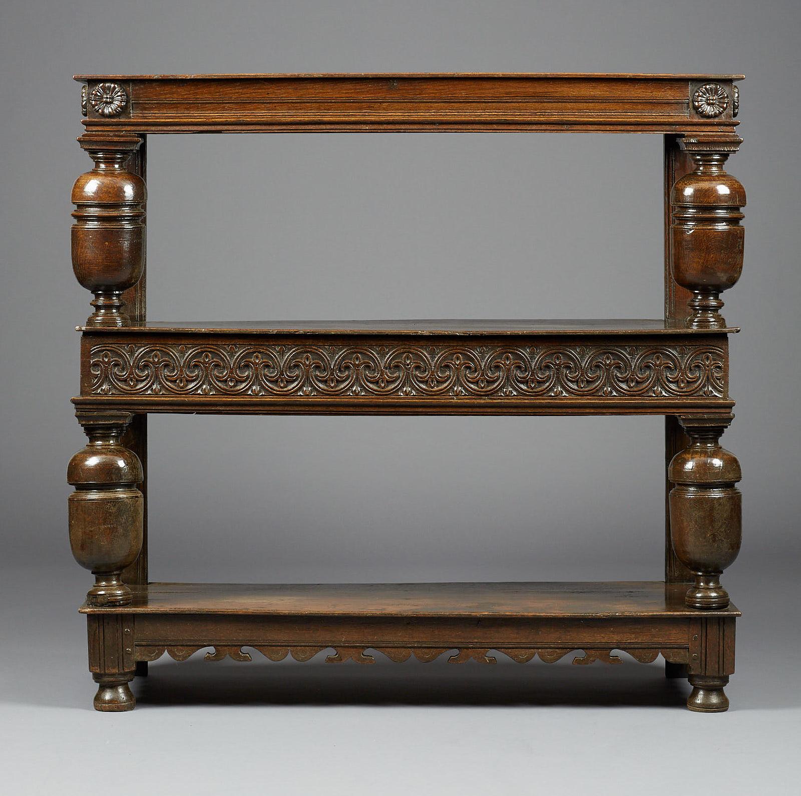 Charles I Oak Three-Tier Buffet, English, East Anglia, circa 1630. 

With deep moulded upper rail flanked by applied floral paterae above bold bulbous cup and cover supports, the middle frieze drawer carved with floral interlaced fleur-de-lys, with