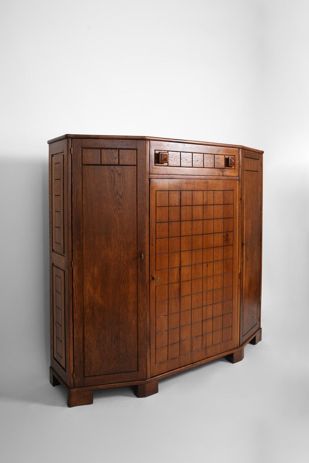 Oak high cabinet with a checkered pattern opening with three doors and a frieze drawer. France, 1940s.