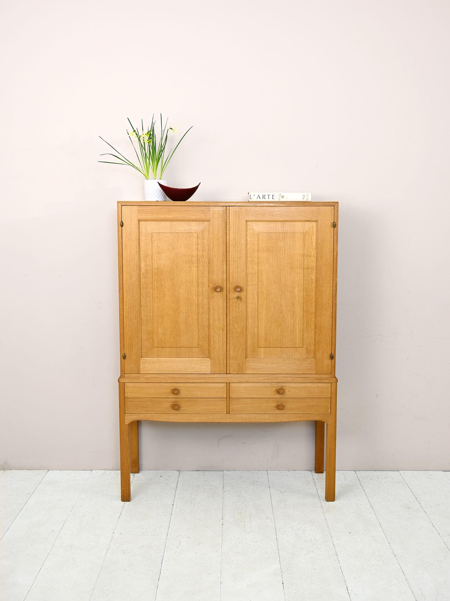 Swedish vintage closet.

File cabinet with hinged doors and drawers.
Inside is a compartment equipped with three adjustable-height shelves.
The long square legs slender and lighten the whole figure.
Thanks to the light color of the oak wood, it