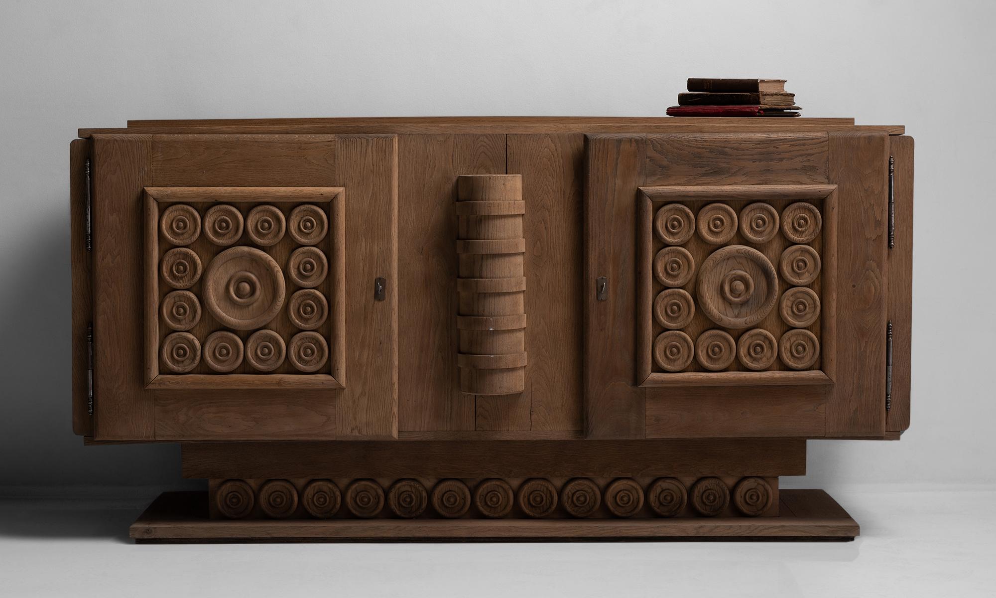 Oak cabinet by Charles Dudouyt, France, circa 1940.

Two door oak sideboard designed by the decorator Charles Dudouyt. With carved decorative details and original hardware and keys.