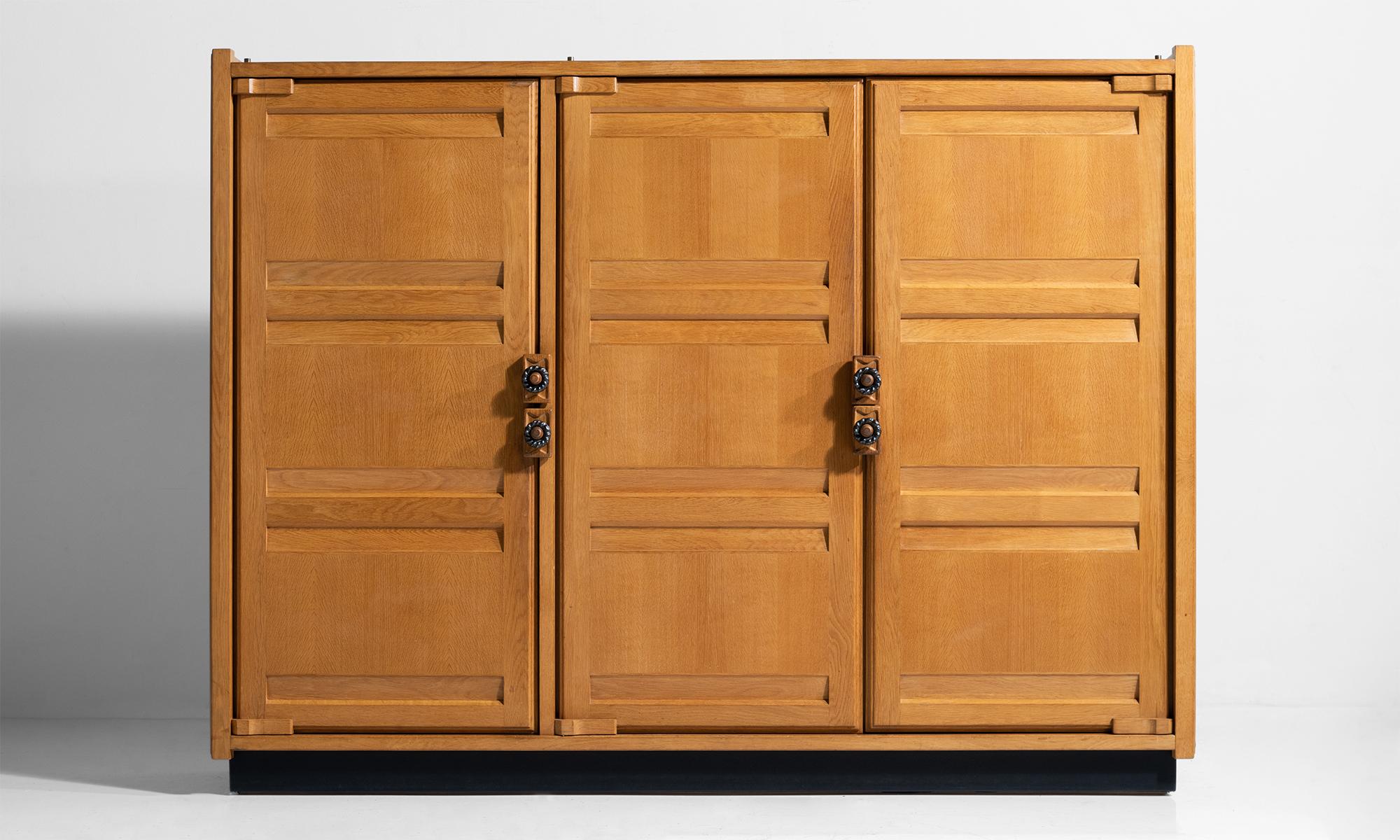 Oak cabinet by Guillerme et Chambron.

3-door solid oak cabinet with ceramic handles.
  
