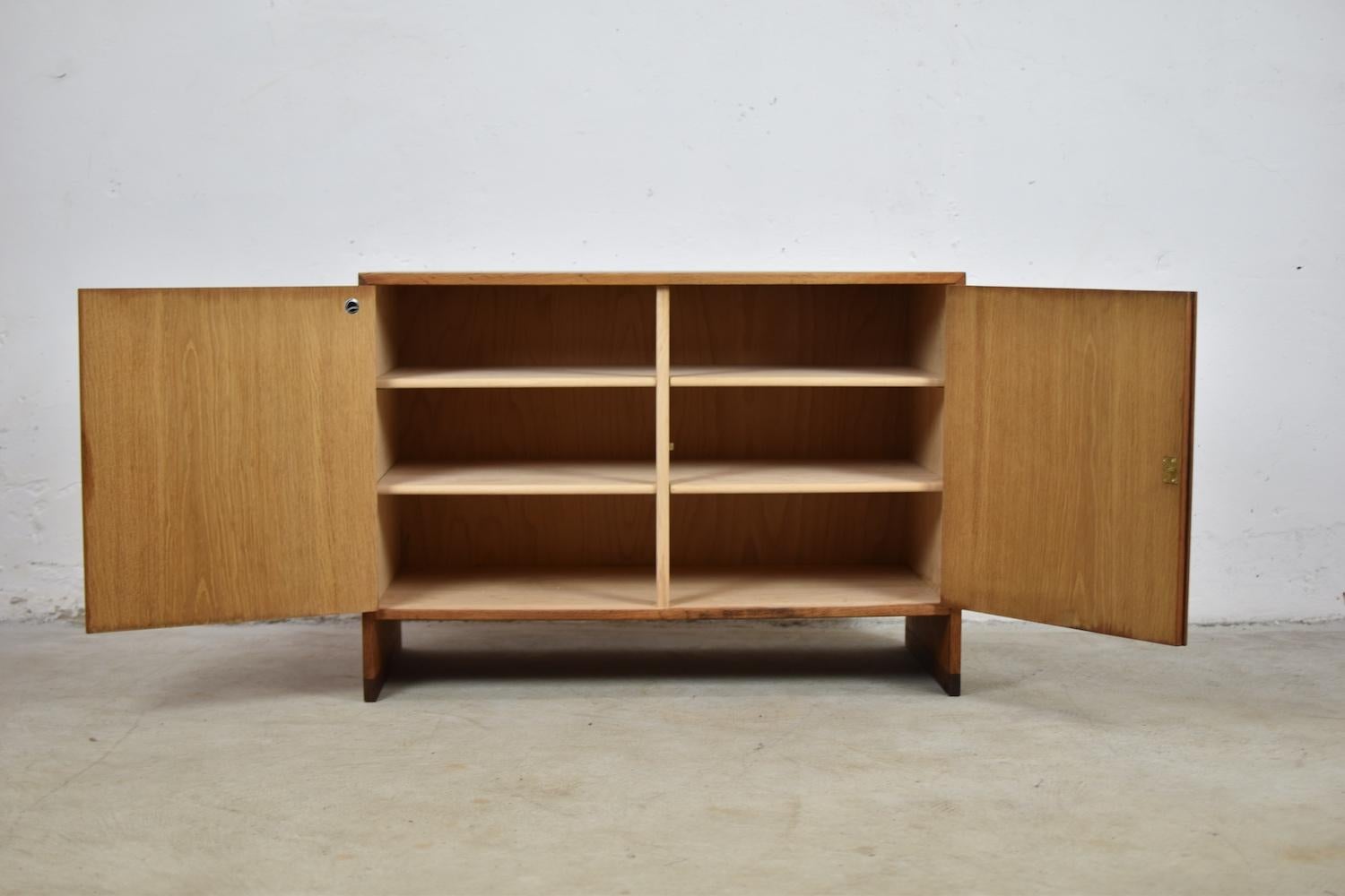 Lovely cabinet by Hans Wegner for RY Møbler, Denmark, 1954. This cabinet is made out of oak and has two doors and four shelves with an elegant brass handle for entering the storage area. Nice grain on the oak. Scandinavian simplicity!