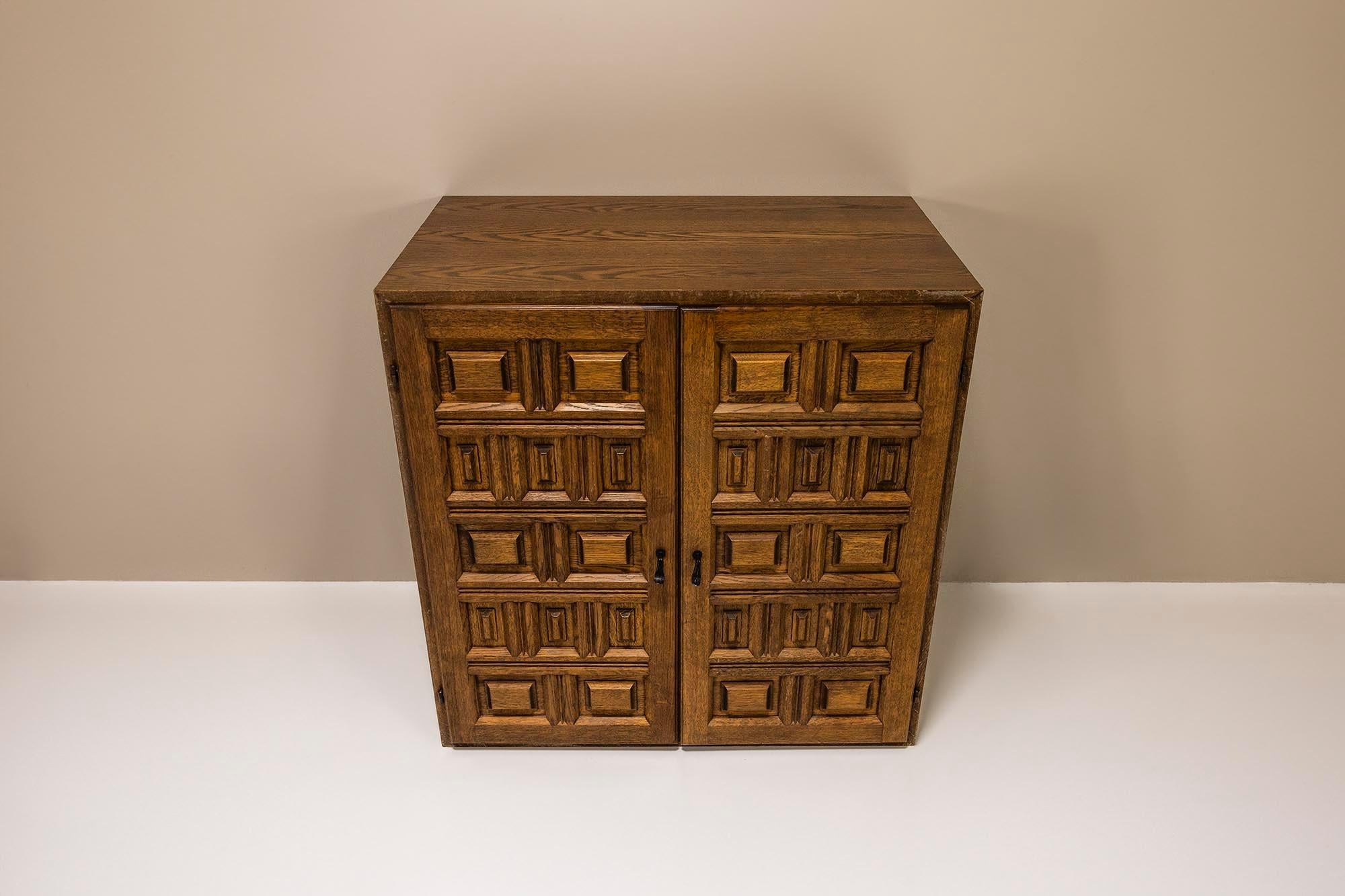 Charming small, but practical cabinet in oak. 

Design
This cabinet is in the similar style as the Spanish brutalist side- and lowboard. The graphical details on the fronts of the cabinets are similar to the sideboard and consist of both horizontal