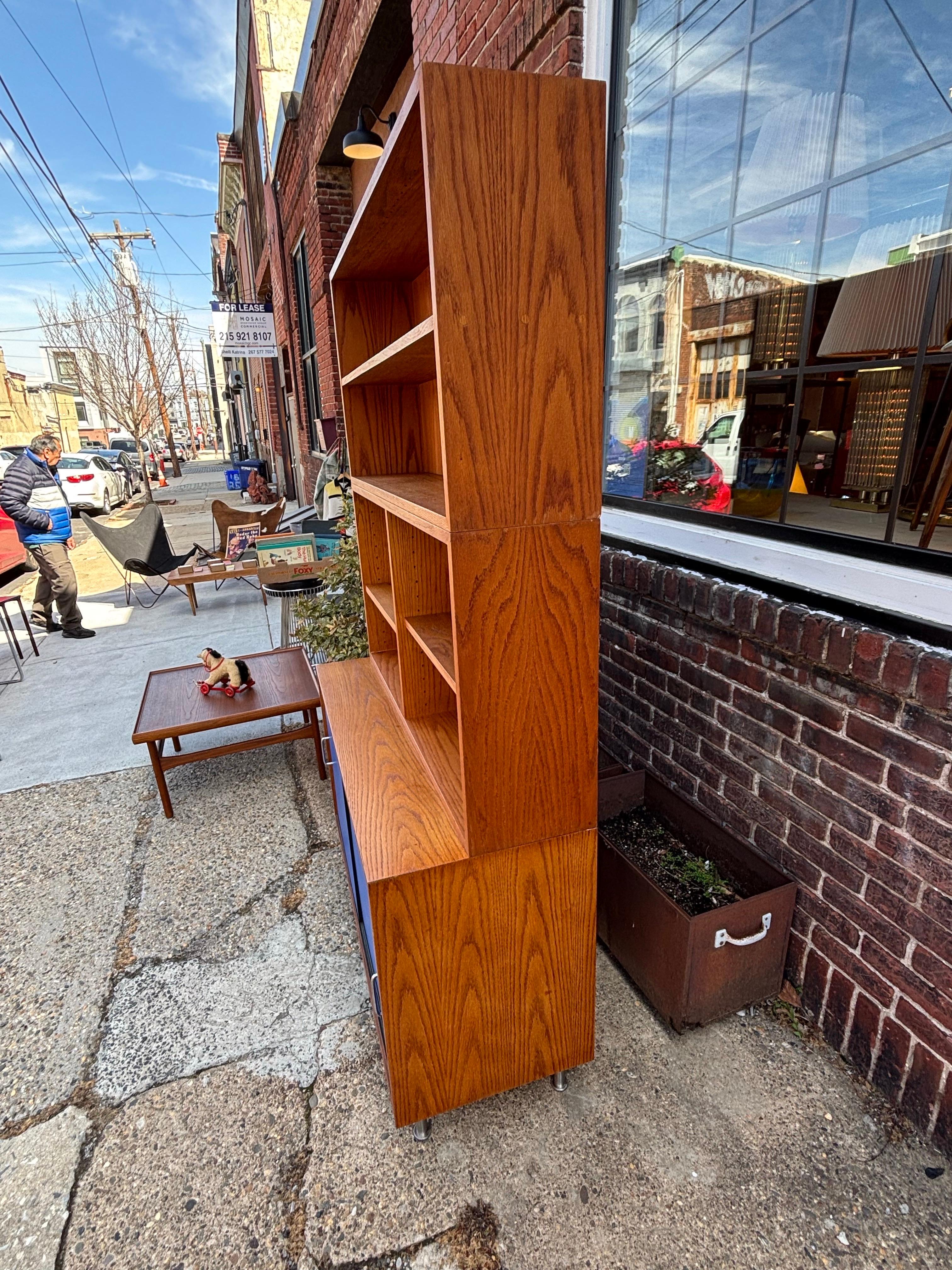 Mobile in Oak con ante scorrevoli in masonite blu e ripiani superiori regolabili.  I pezzi superiori possono essere utilizzati o conservati, girati su un lato o utilizzati in verticale.  Grande spazio di archiviazione!  Le ante scorrevoli si aprono
