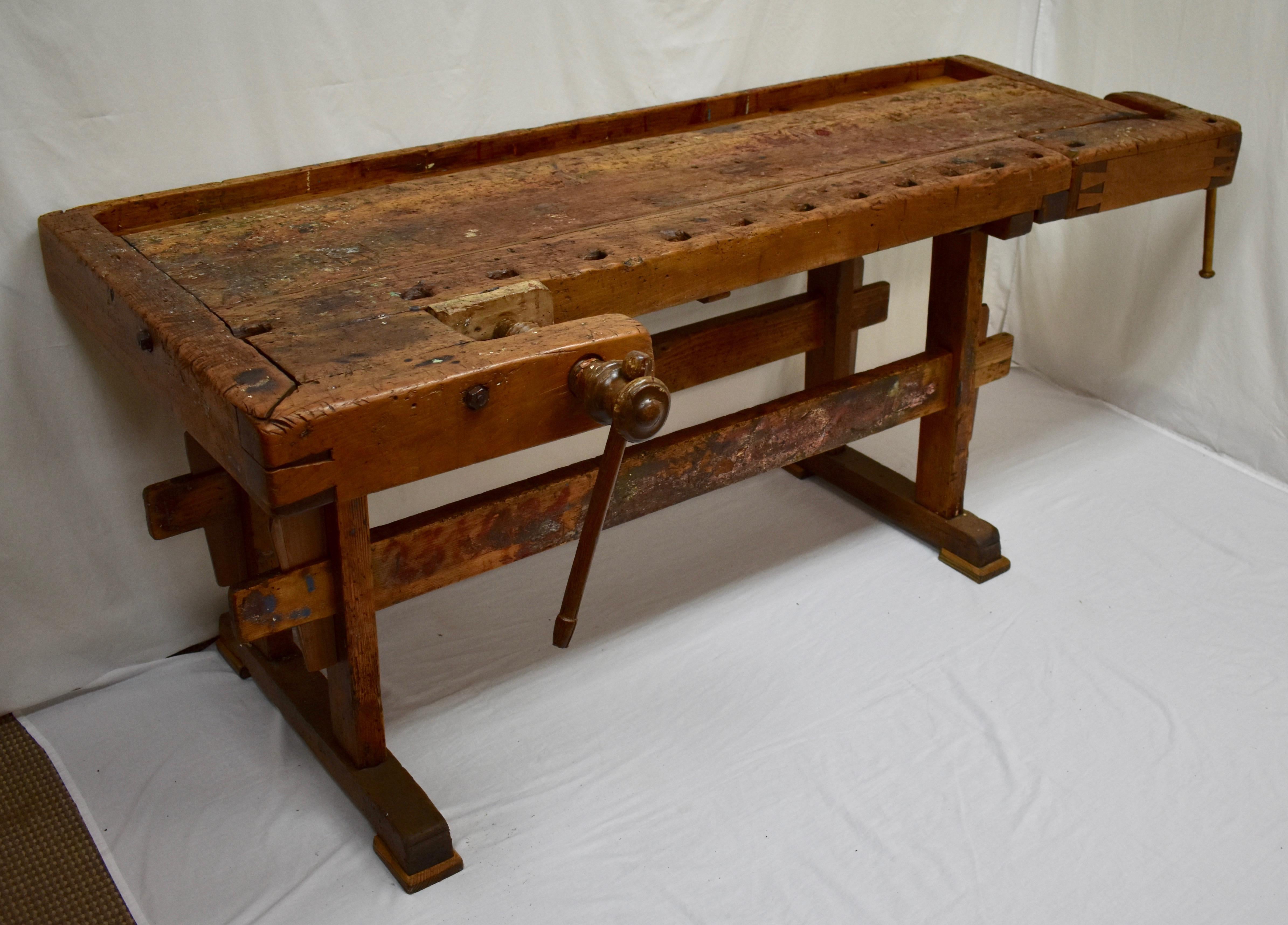 This massive oak Joiner’s workbench is built as solid as a rock and has been chopped, scraped, scratched and whacked through decades of purposeful use. The trestle-style base is made of pine and oak. The uprights are 2” x 4” boards of yellow pine,