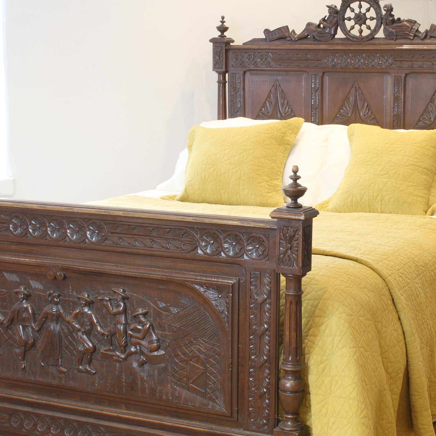 A superbly carved bed in oak with decoratively panels featuring dancing figures and musicians.

This bed accepts a British king size or American queen size, 5ft wide (60 inches or 150cm) base and mattress set, with an overlap (as shown)

The price