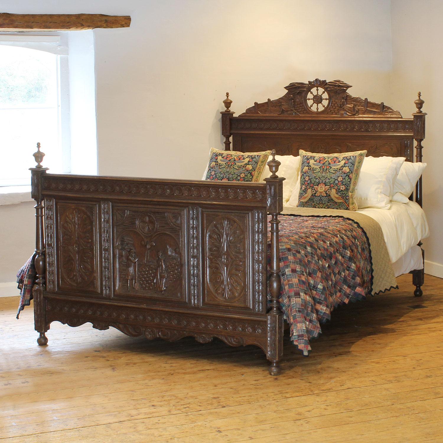 A superbly carved bed in oak with decoratively panels featuring rural figures.

This bed accepts a British king size or American queen size, 5ft wide (60 inches or 150cm) base and mattress set, with an overlap (as shown)

The price includes a