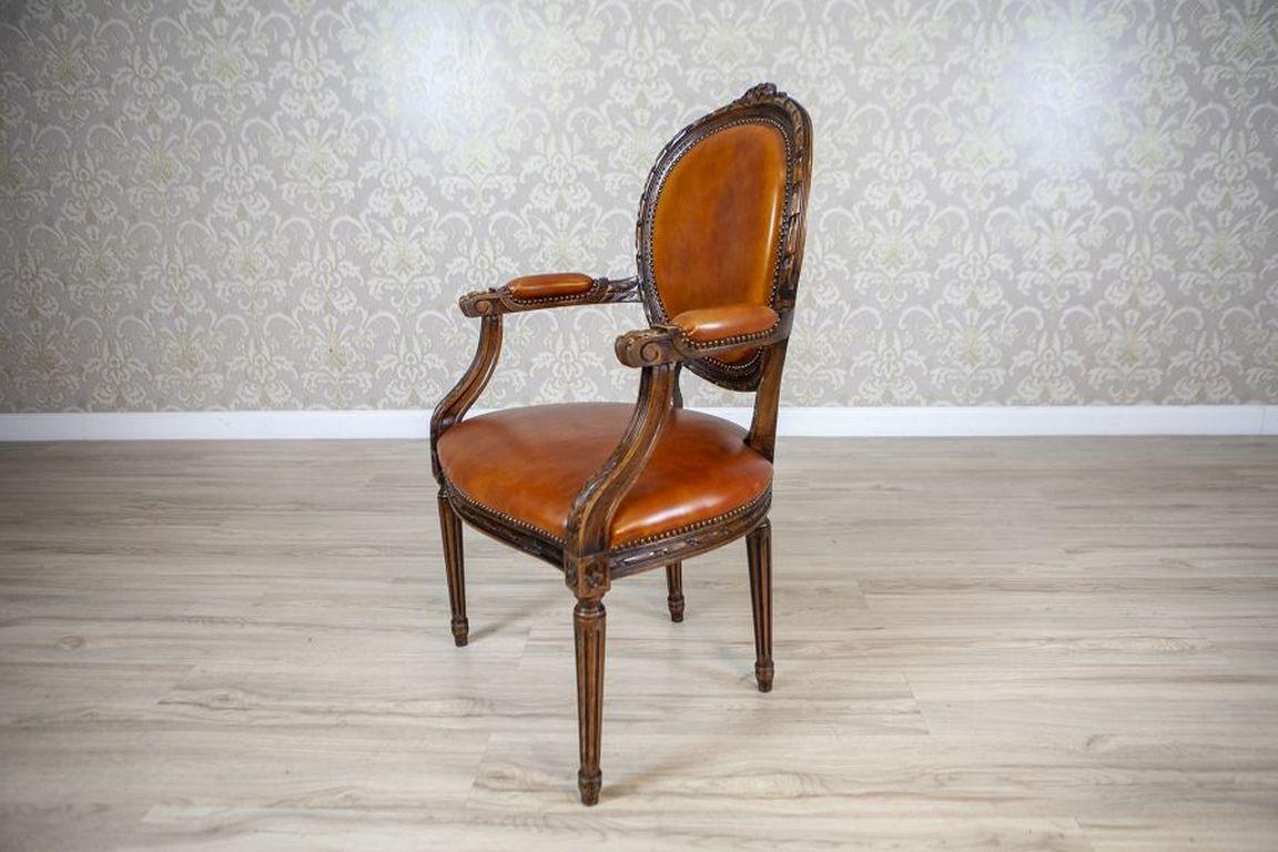 Oak Carved Armchair From the First Half of the 20th Century

A stylized carved armchair from the early 20th century. This beautiful chair is crafted from oak wood, with a leather-upholstered seat, backrest, and armrests finished with upholstery