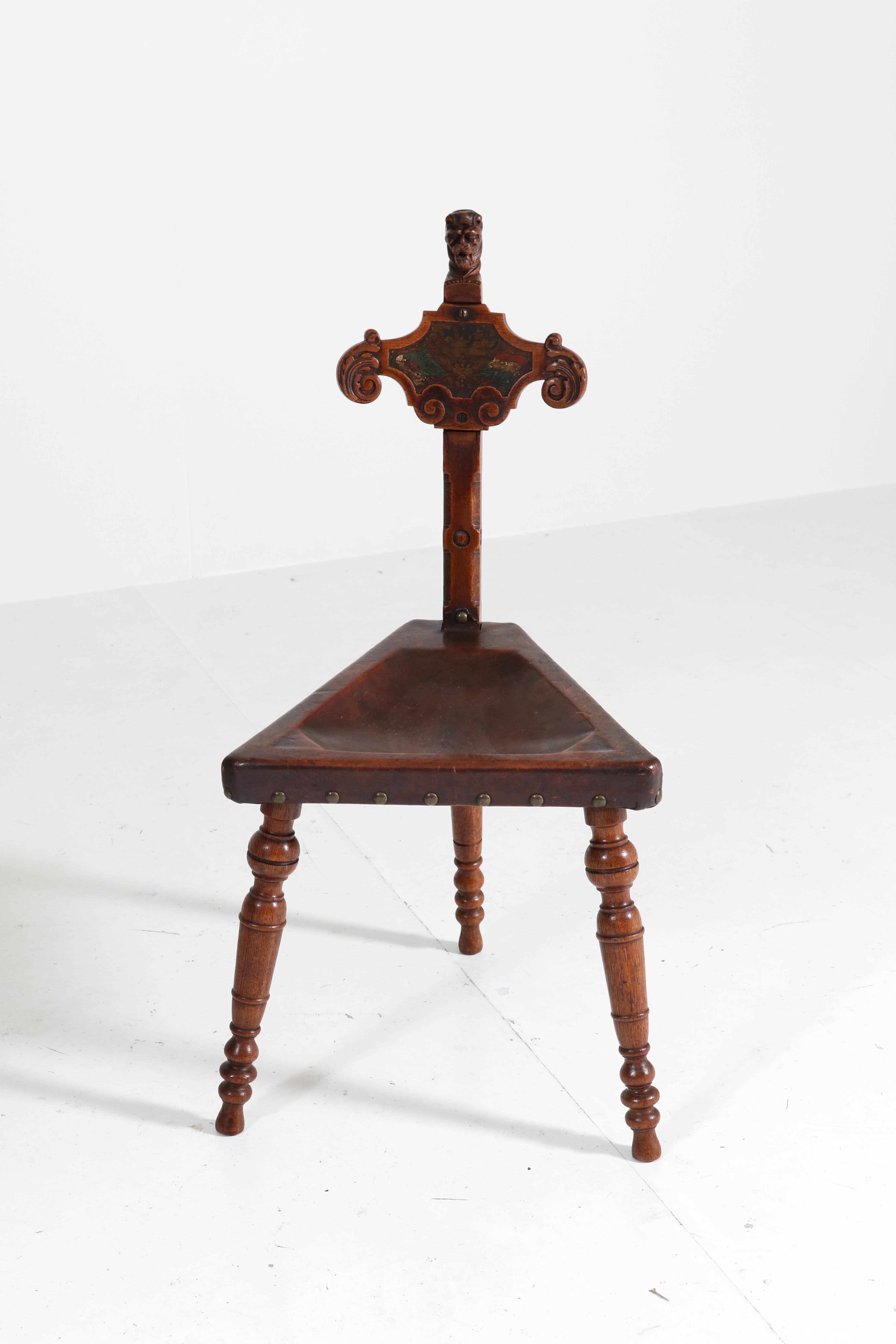 Wonderful and rare Renaissance Revival tripod chair from circa 1900.
Solid oak with original leather seat.
Carved head of a lion and hand painted flags of the Netherlands and Portugal.
In very good condition with minor wear consistent with age