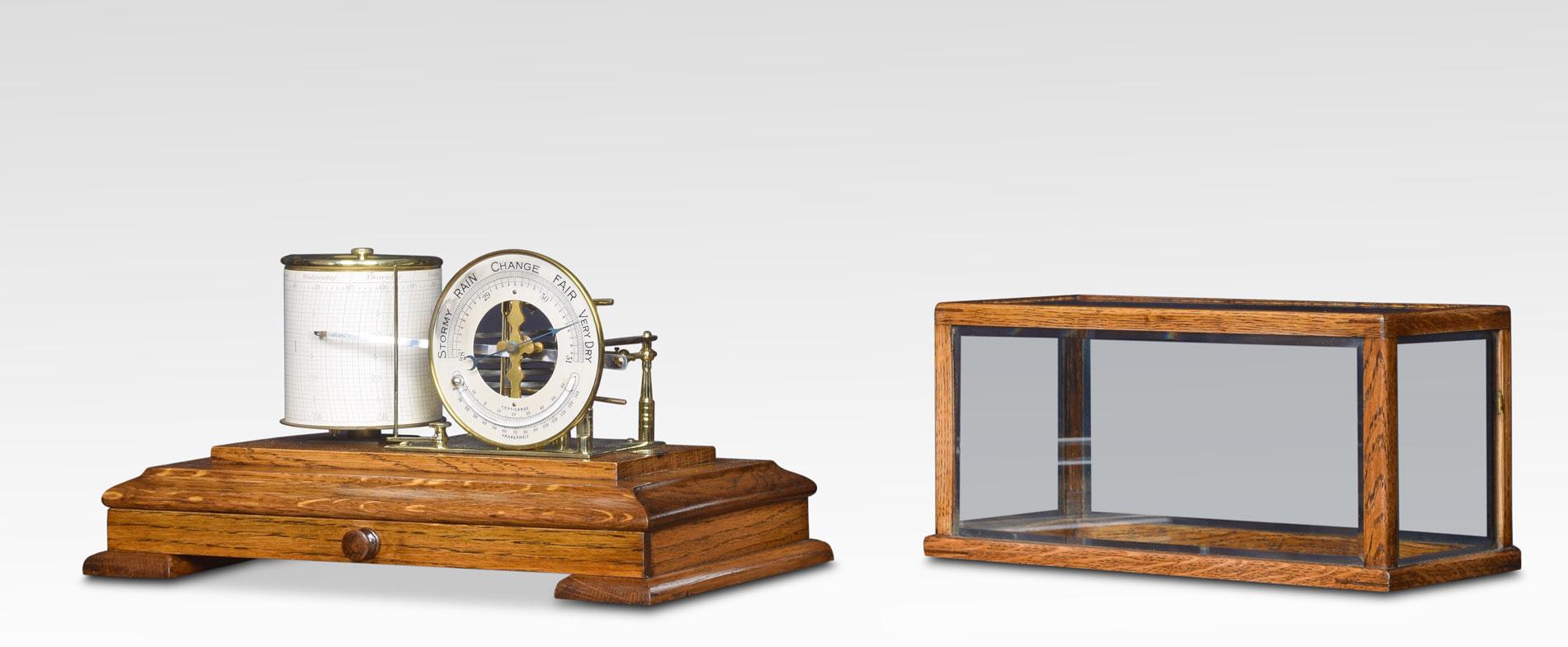 Oak cased barograph and barometer, having five bevelled glass panelled removable lid, and a drawer below to house the charts. The mechanical eight-day movement is housed in the drum, fitted with a seven-day chart which covers one full rotation of