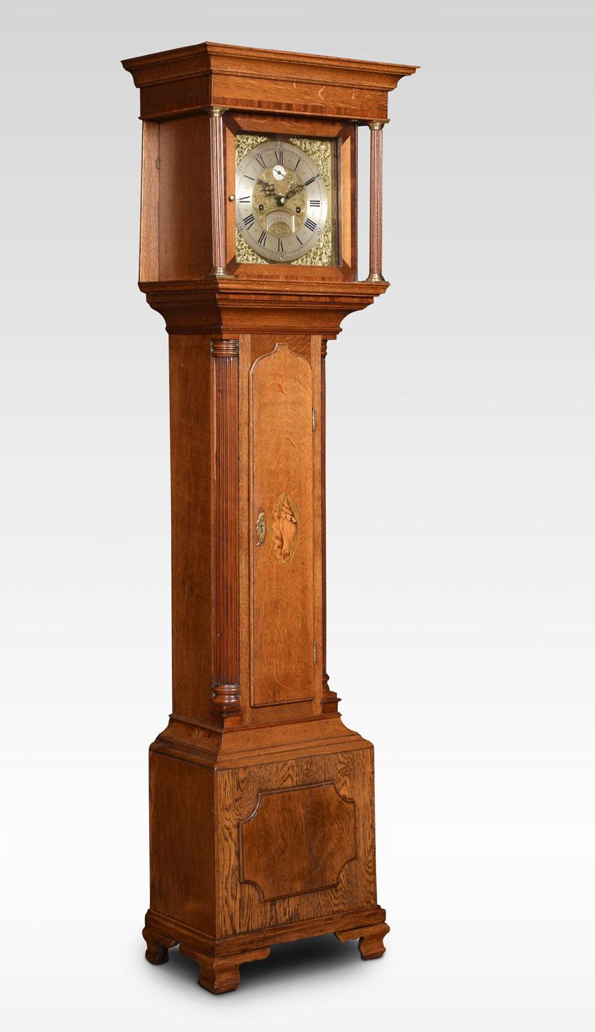 Oak cased grandmother clock by Patterson London, having eight day two train weight driven movement chiming on a bell. The silvered chapter ring with Roman numerals and scroll and floral cast spandrel mounted corners. Flanked by Corinthian columns,