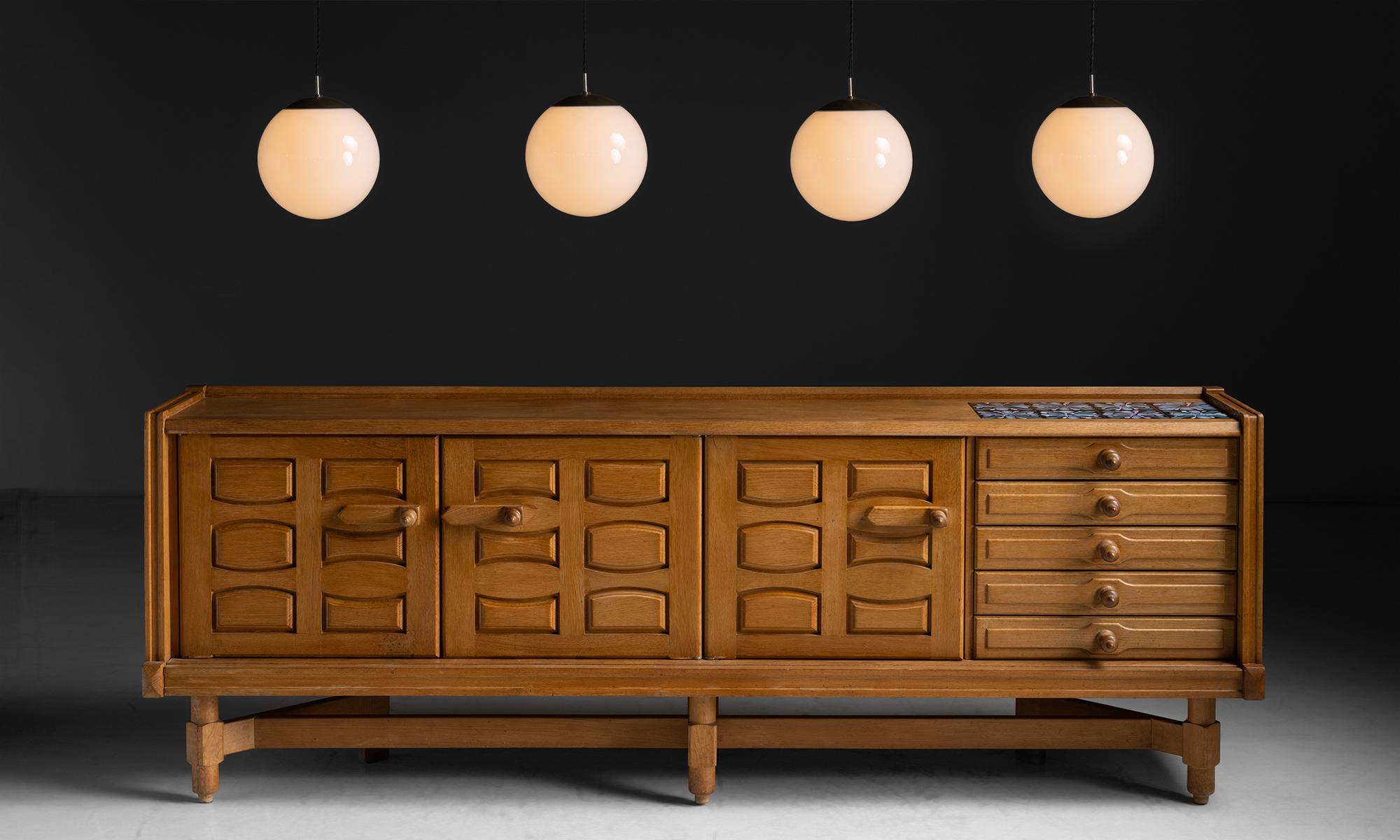 Oak & Ceramic Sideboard by Guillerme et Chambron, France, circa 1960

Golden oak sideboard with modern carving and original tiles on surface.

Measures 103”L x 20”d x 37.5”h