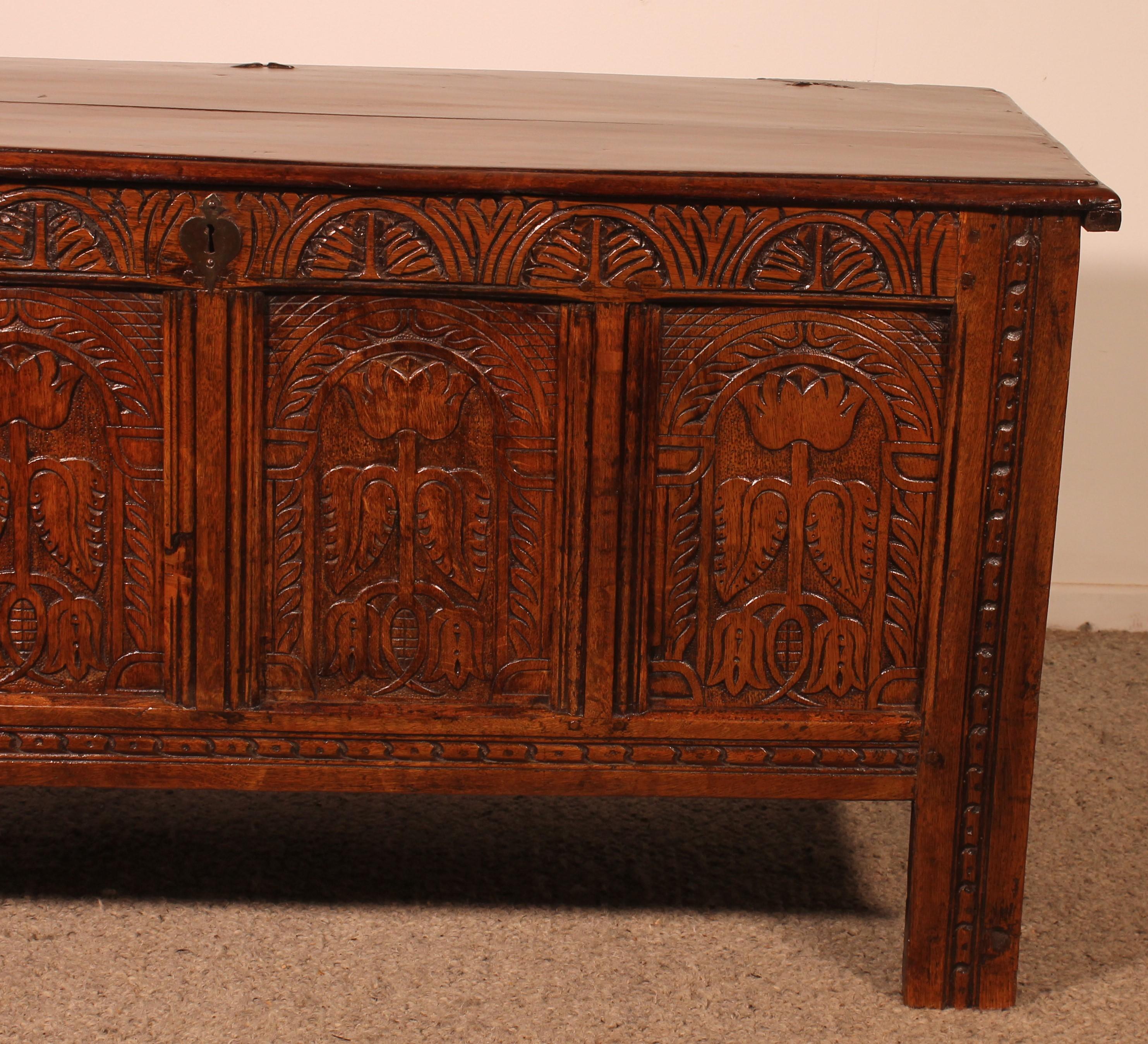 Superb English chest from the 17th century in oak composed of 4 panels
 rare chest due to its quality of sculpture which is exceptional and its 4 panels since very often 3 panels
Very beautiful decor describing arches with flowers inside
Paneled
