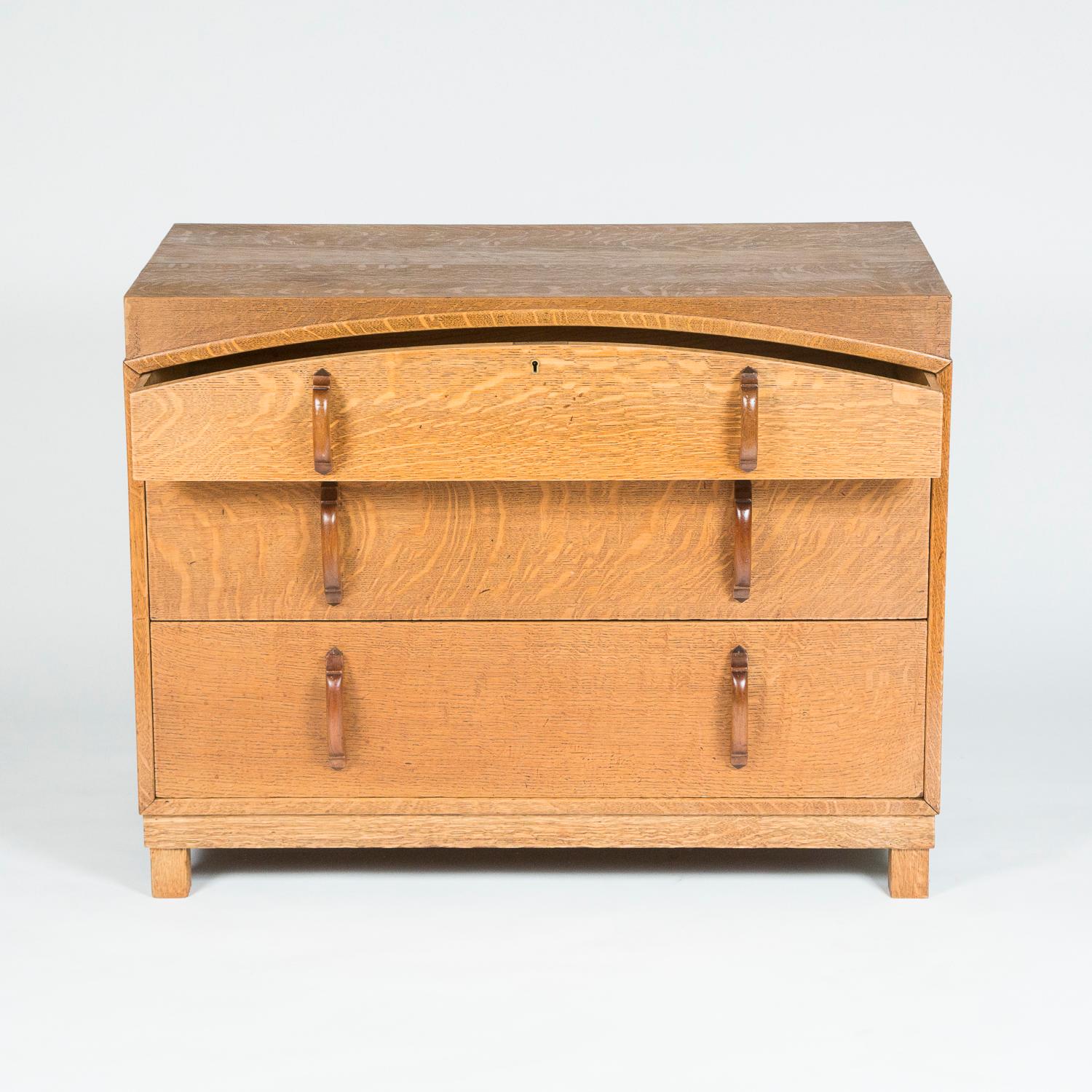 A light oak three drawer chest of drawers by James Schoolbred of London. 

Maker's label inside top drawer. (JAS SCHOOLBRED & Co Ltd TOTTENHAM COURT Rd LONDON W.1.) 

James Shoolbred and Company was a draper and later a department store, located