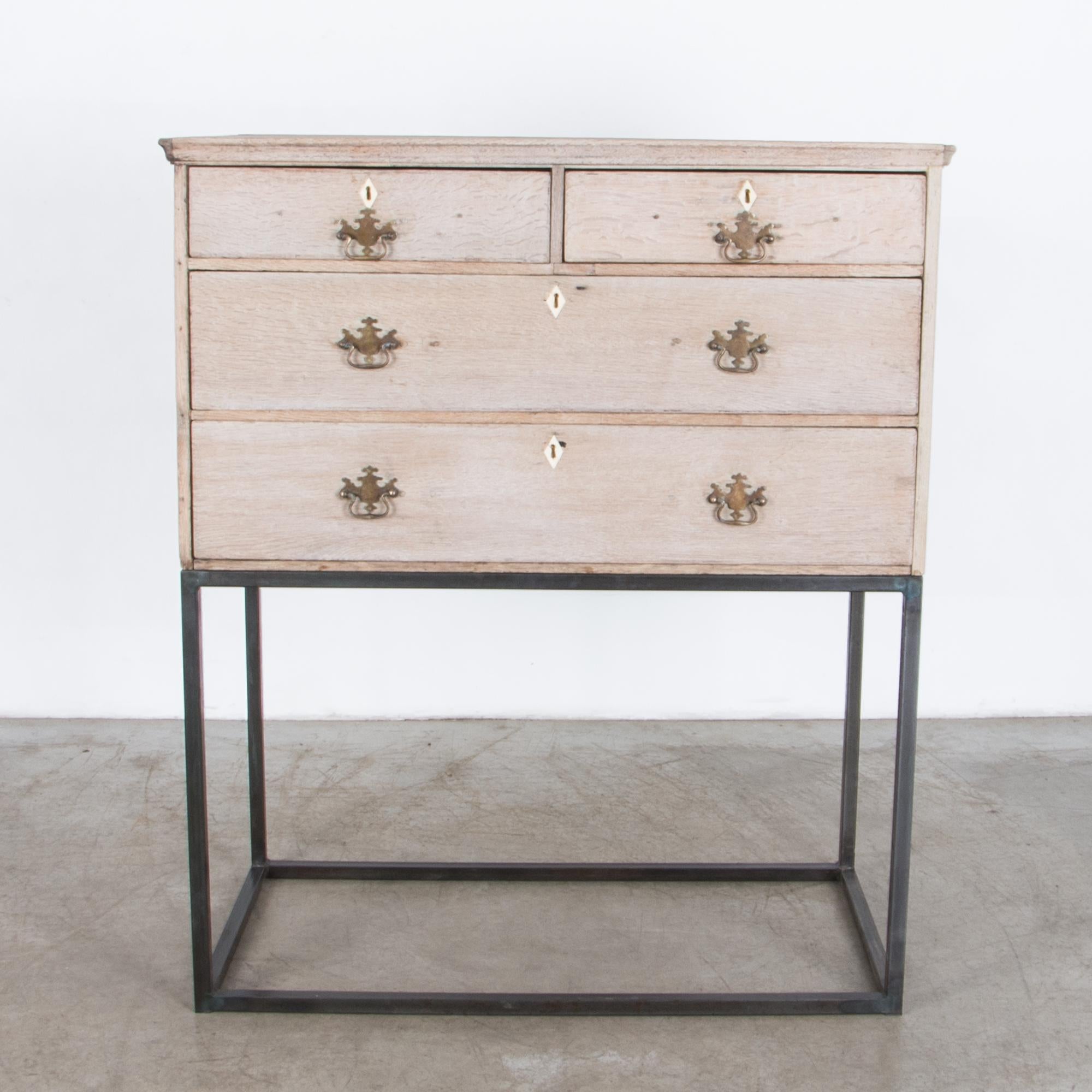 From The United Kingdom circa 1880, a four drawer chest with refined and simple shape, rests on a minimal steel base. Contrast of texture and color enhances the geometric volume of each element. Subtly refined, with brass hardware and upper moulding.
