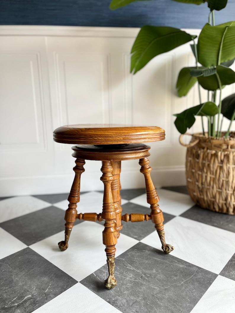 This well-kept oak piano stool comes from a Victorian family home where it lived in the front parlor beside an upright piano. The children learned their first scales on it. It was pulled into holiday gatherings, used at the writing desk, borrowed