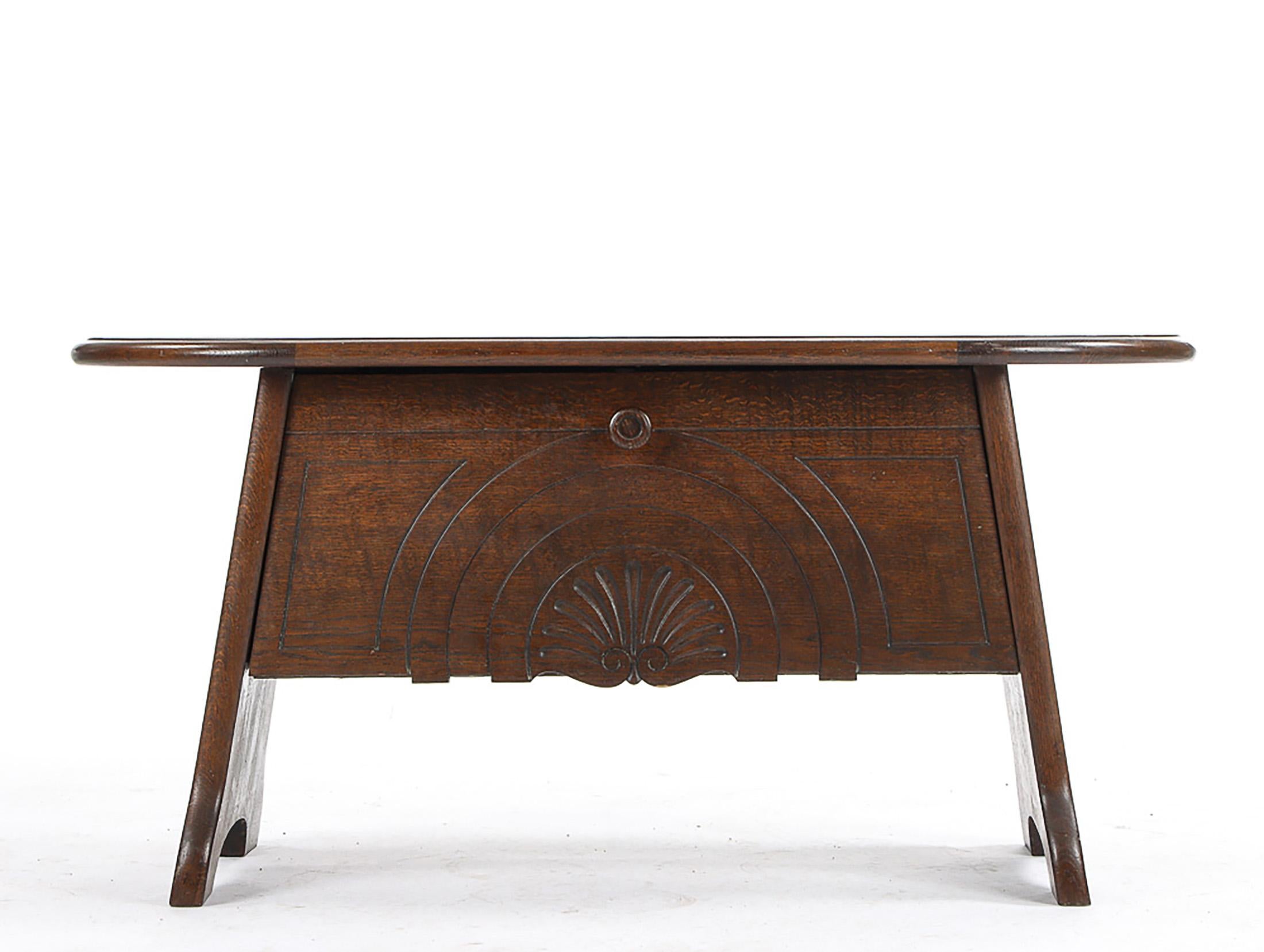 Table basse en chêne teinté foncé, munie d'un abattant rabattable sous le plateau, première moitié du XXe siècle. 
H. 55, L. 115, P. 50 cm.
Bon état d'origine.