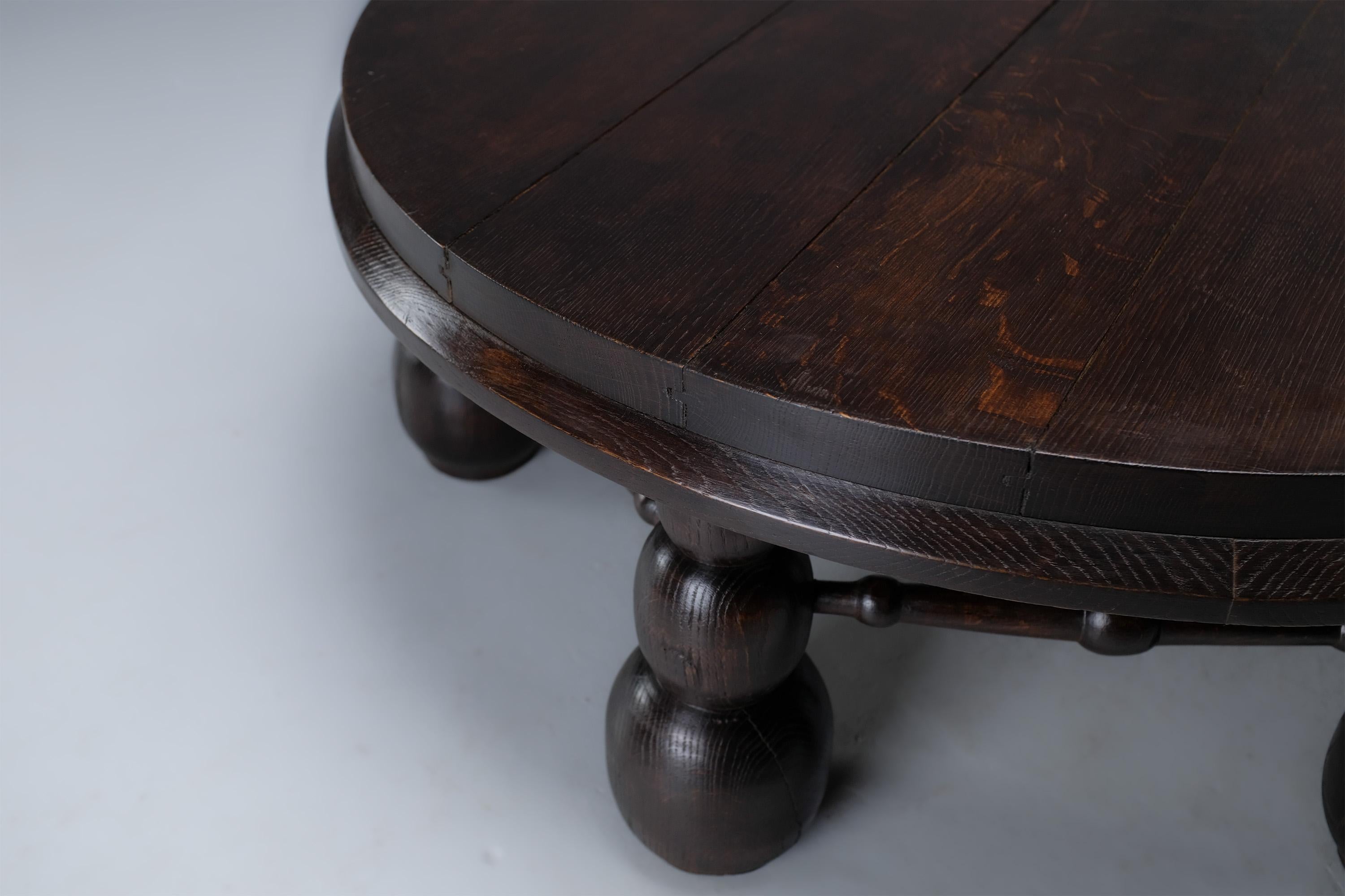 This rare coffee table made of oak shows an art deco style and marks of experience that make its creation estimated to be around the 1930s.

Its robust structure has six wide legs with rounded geometric patterns, which support a thick round