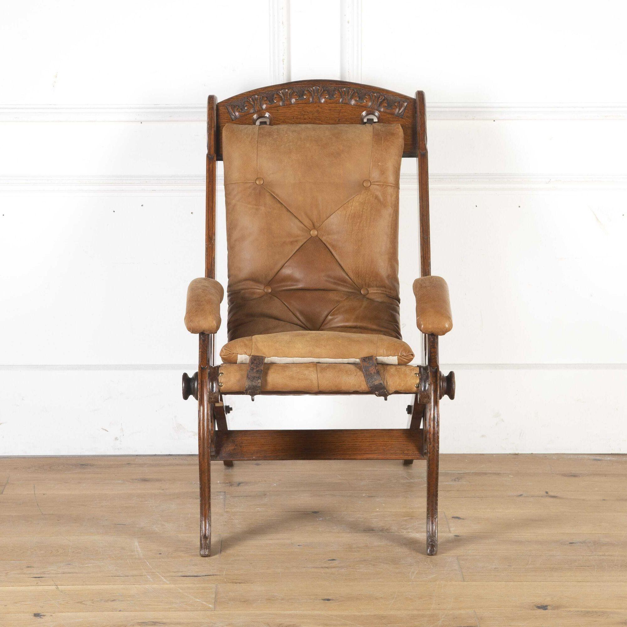 19th Century oak folding and reclining colonial campaign chair. 
This chair was designed for comfort, with a buff leather slung seat and leather padded arms. The original design is attributed to J. Herbert McNair, who was part of the Glasgow group