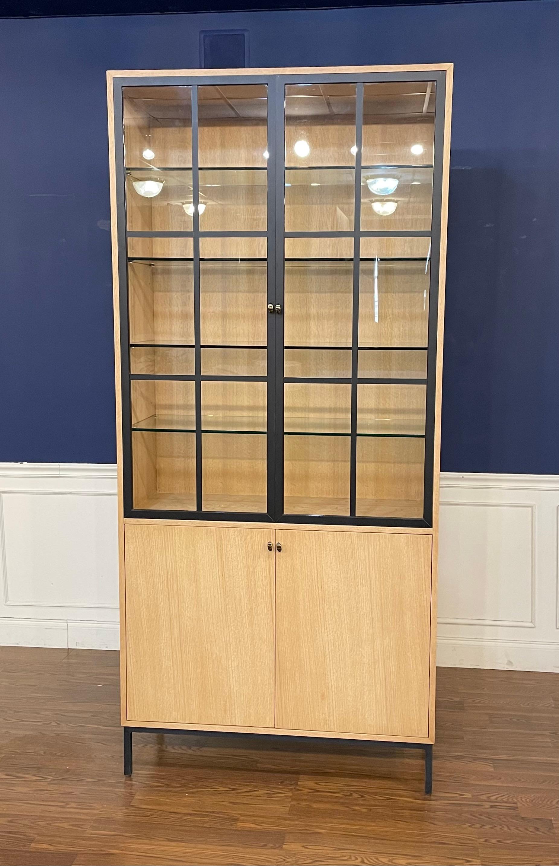 This is the Open Sky Tall Display Cabinet made by Century Furniture.  This display cabinet features oak veneers with a natural finish and black metal accents.  It has a modern design which is adaptable to multiple areas of the home.  There are four