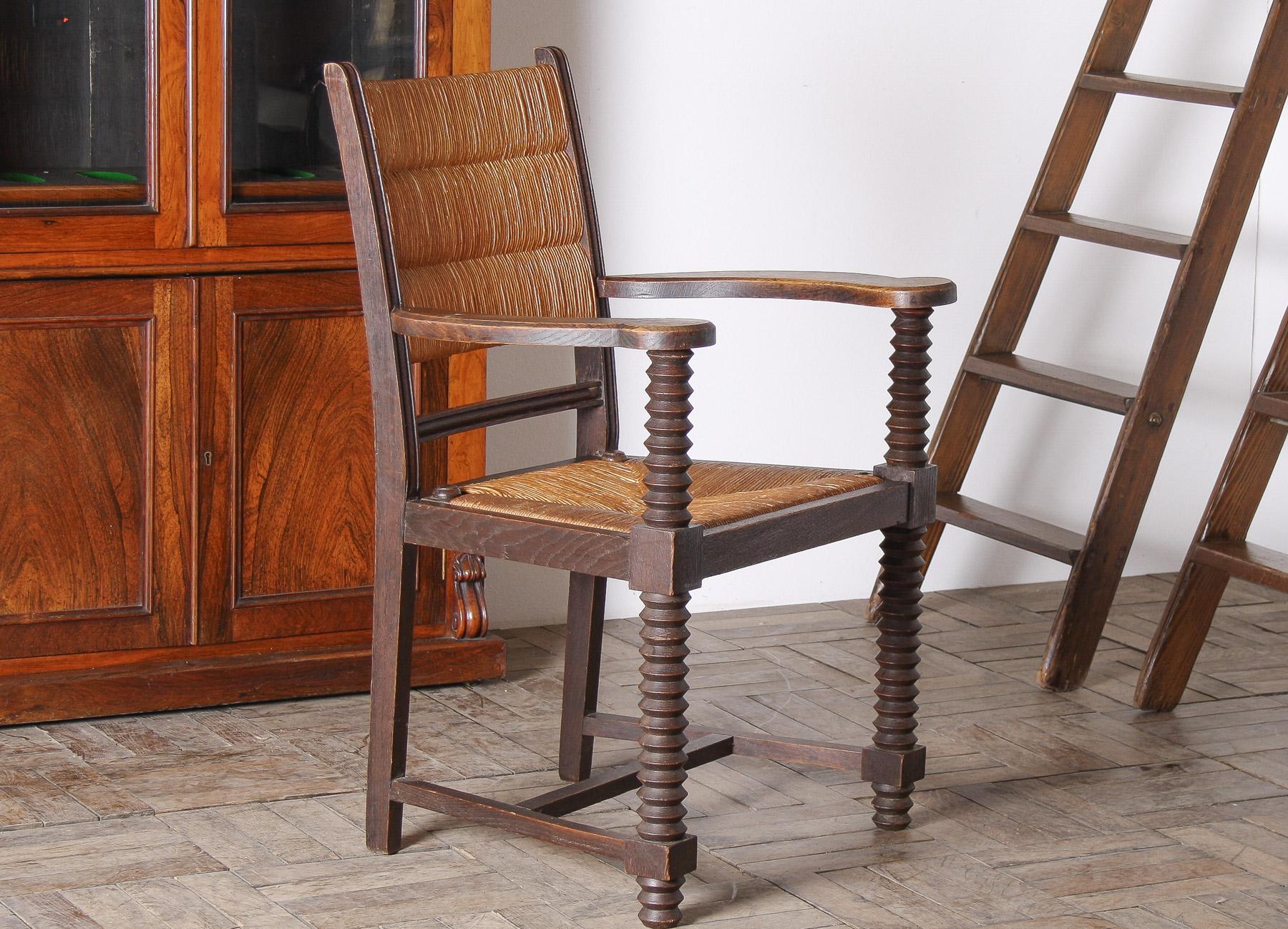 Una poltrona di inizio o metà secolo progettata dal rinomato produttore di mobili francese Charles Dudouyt negli anni '40. Questa sedia presenta le iconiche gambe tornite a forma di cavatappi di Dudouyt, completate da una seduta e uno schienale in