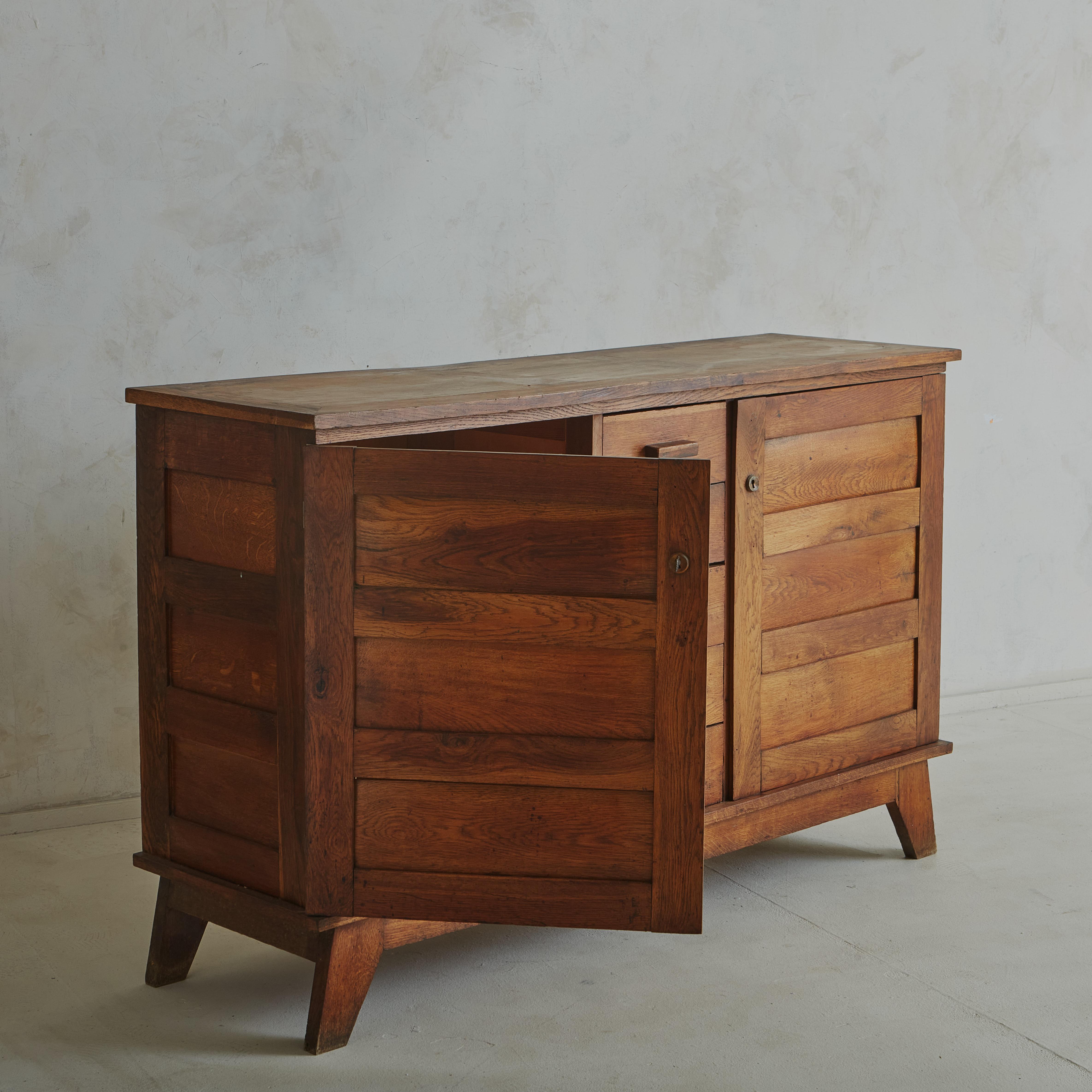 Magnificent oak sideboard by René Gabriel, designed between 1945 and 1950 during the postwar reconstruction period. Featuring two doors and five drawers with an original key and compass legs. The chest is in great condition. The original patina is