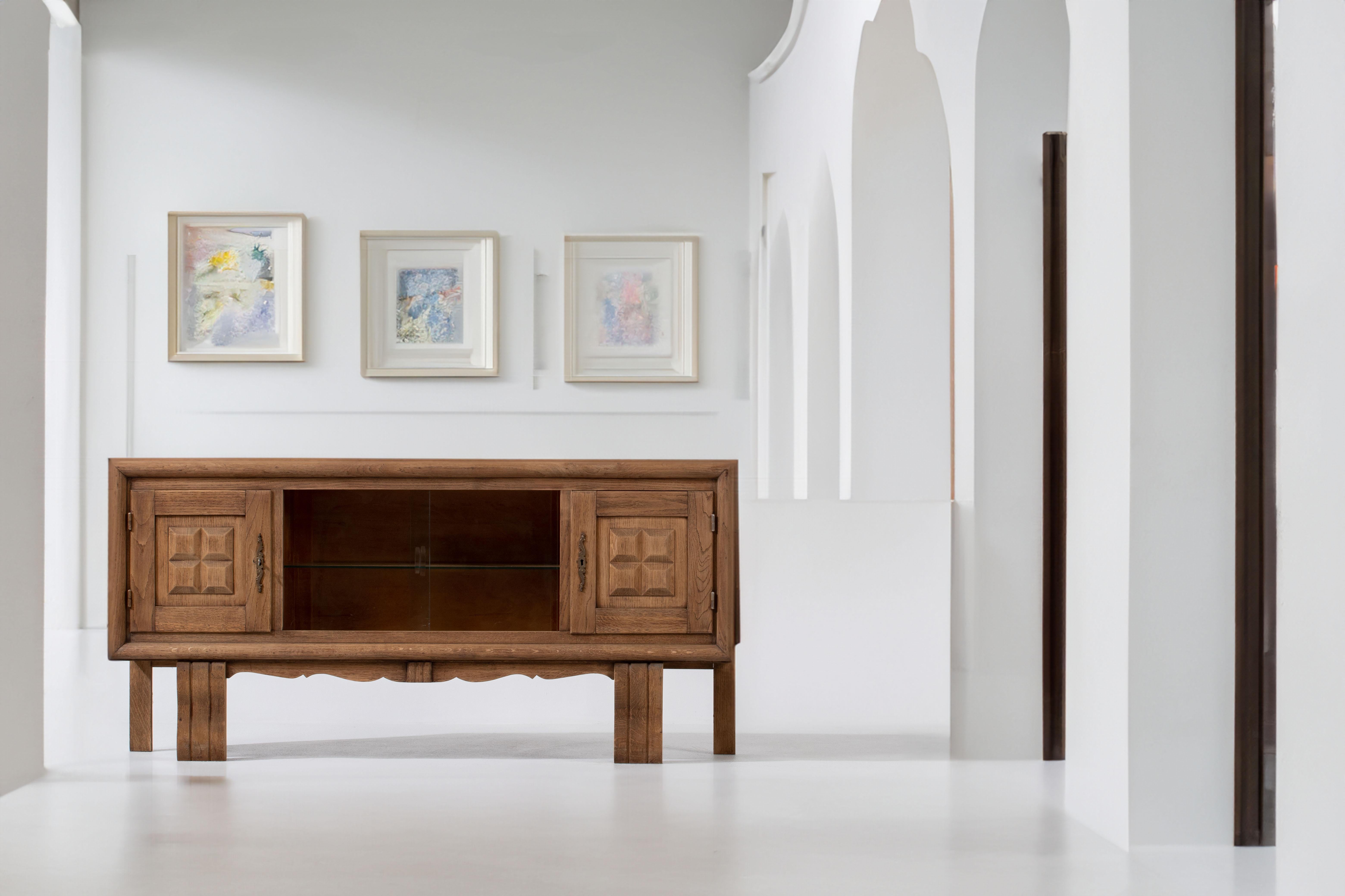 

Experience the refined elegance of this compact oak credenza, evoking the iconic style reminiscent of the renowned designer Charles Dudouyt. Crafted with meticulous attention to detail in 1940s France, this credenza embodies the essence of Art