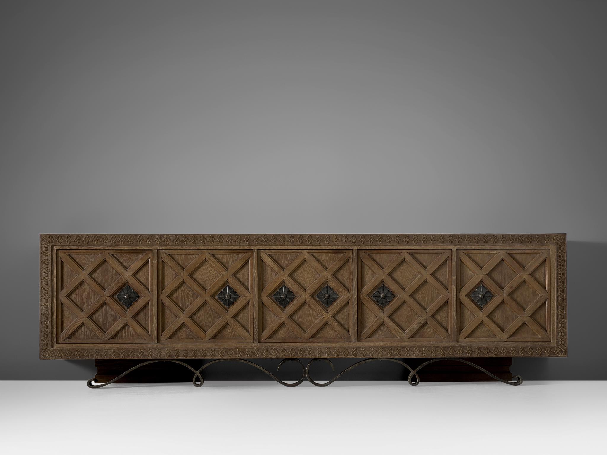 Credenza, in oak and brass, France, 1930s.

This very large credenza with five doors in oak has brass details. All five doors are beautifully designed with wooden graphical patterns. The diagonal lines with added squares and a frame emphasize the